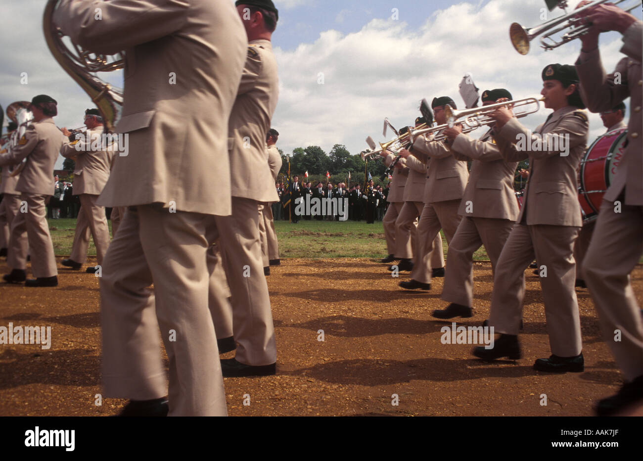 Military brass band plays and marches past veterans of the DDay