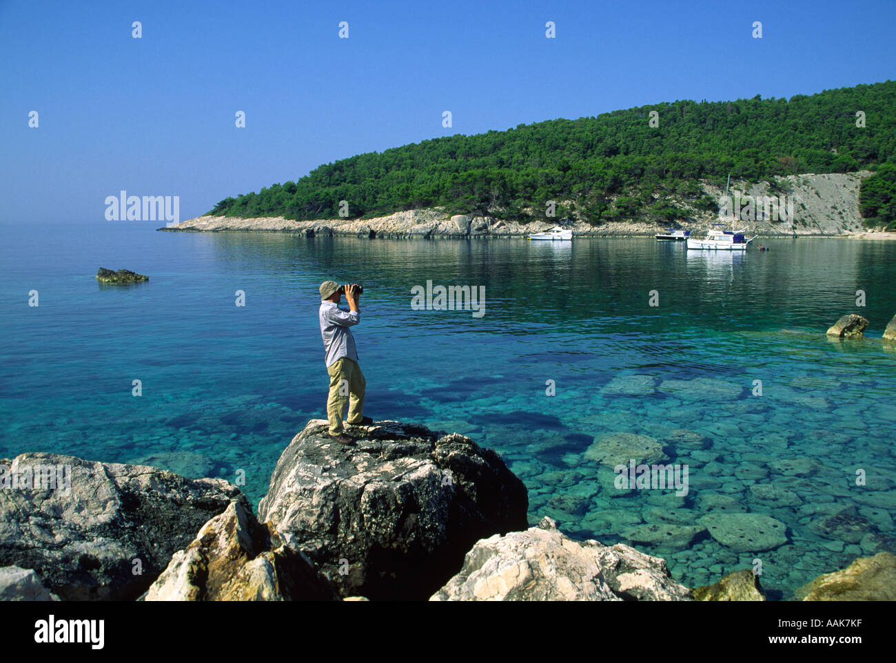 Hvar Rocks Photographer on rocks in a sheltered bay on Island of Hvar, Croatia ...