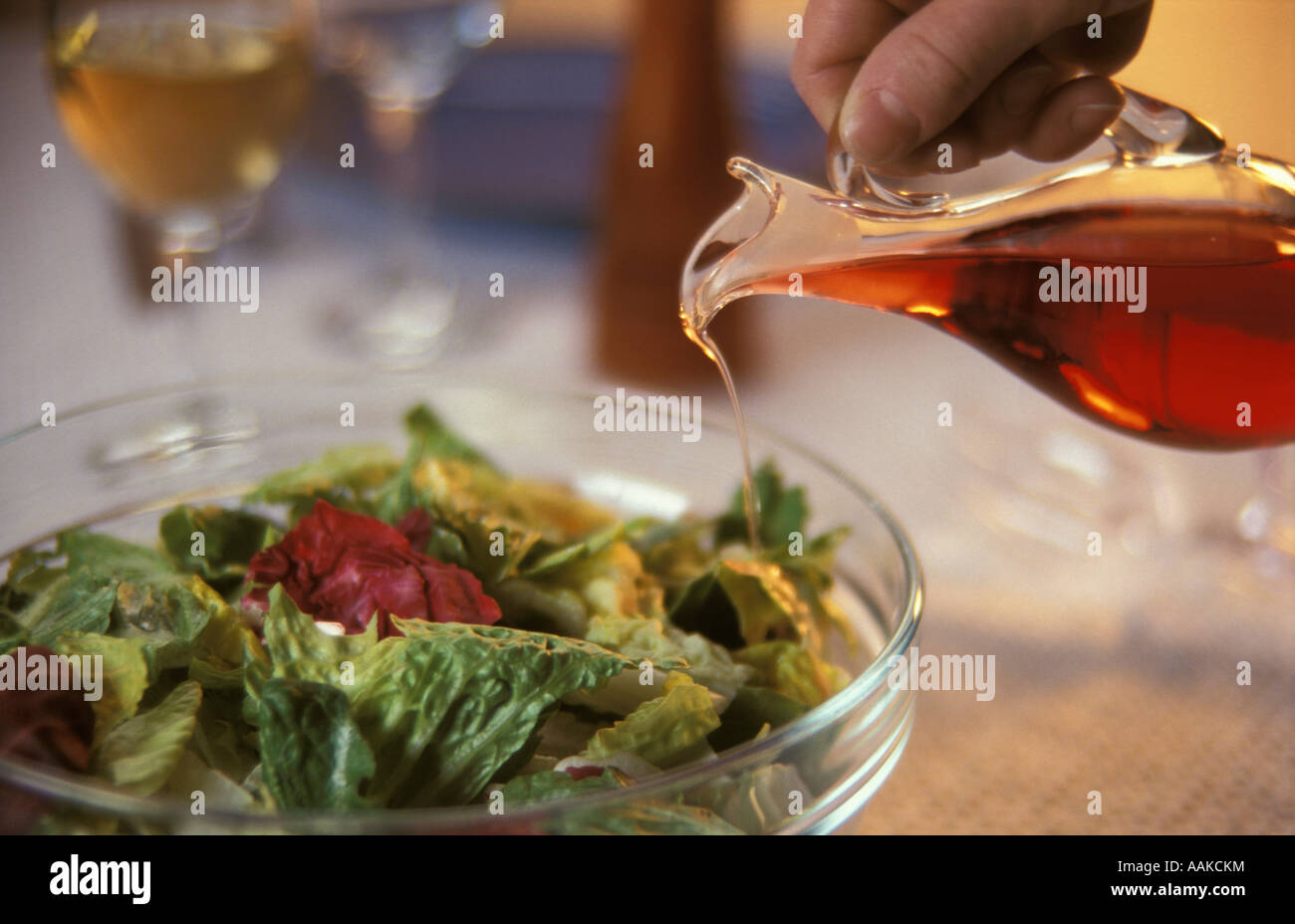 Pouring red wine vinegar on a salad Stock Photo Alamy