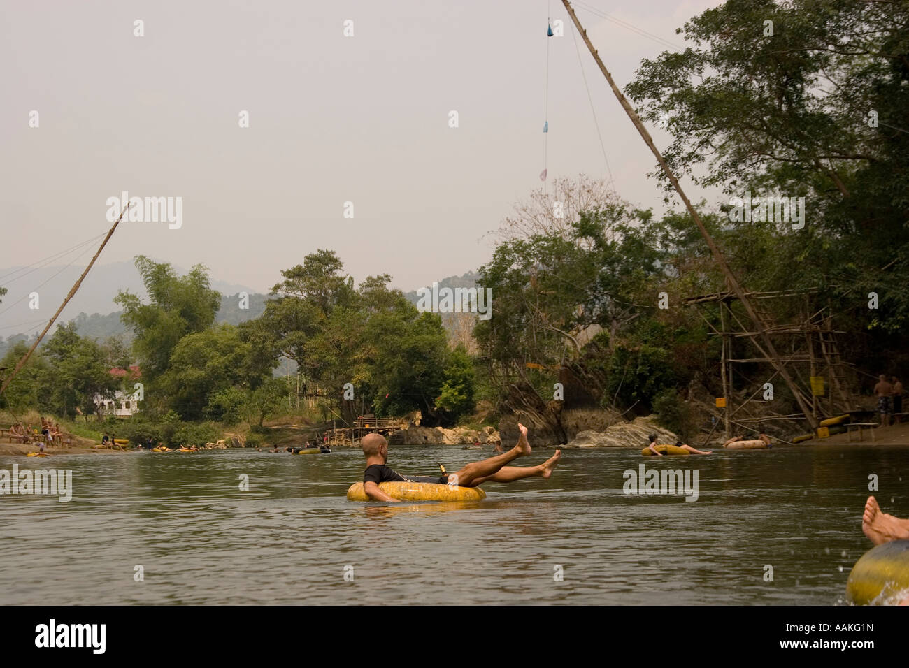 Tubing down the Nam Xong river with rope swings in the background Vang ...