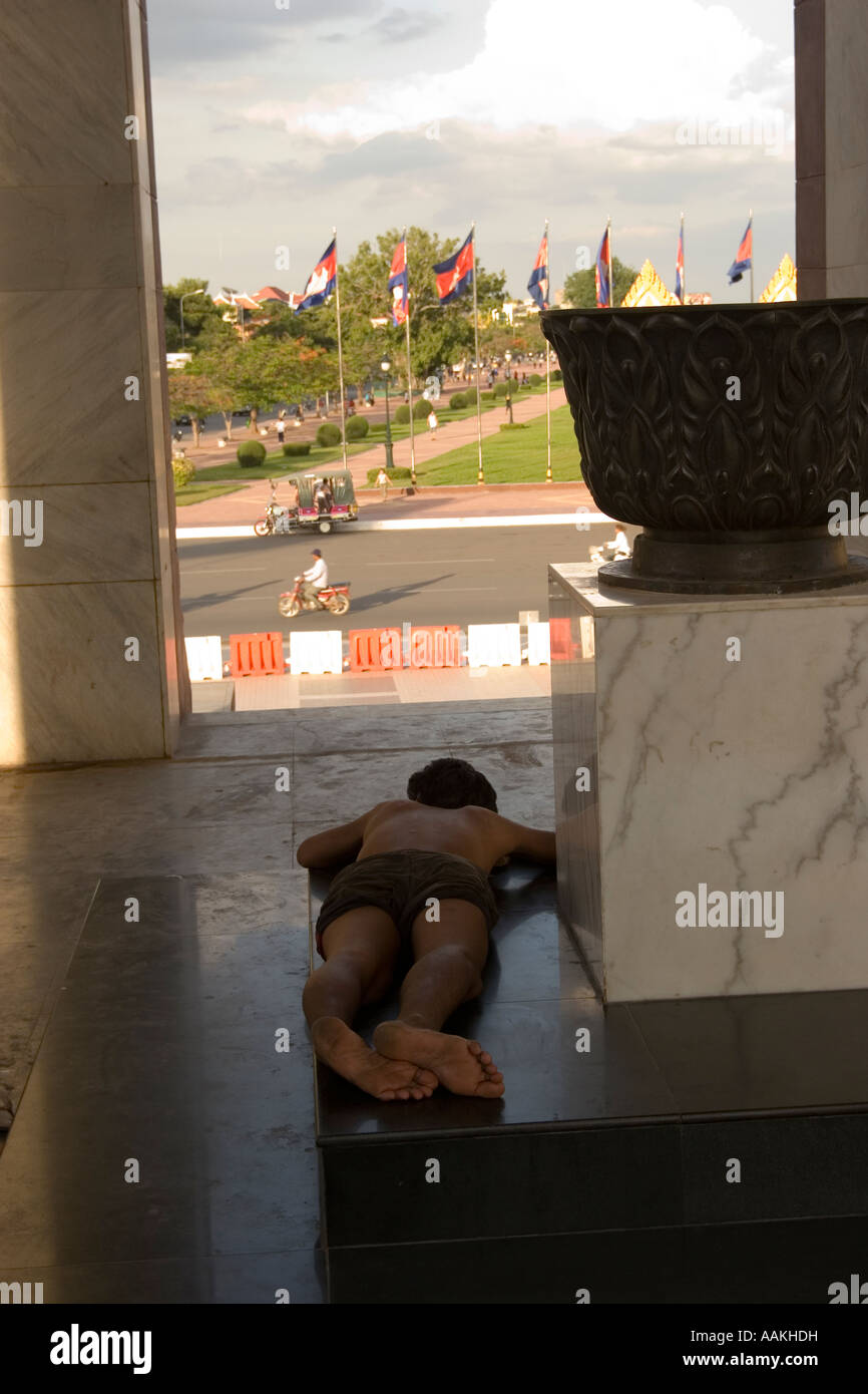 Homeless man sleeps on the floor of the Independence Monument Phnom