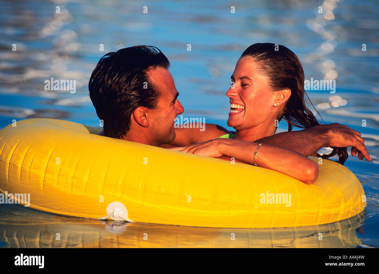 1980s HAPPY YOUNG COUPLE FLOATING IN PLASTIC INNER TUBE IN THE POOL Stock  Photo - Alamy