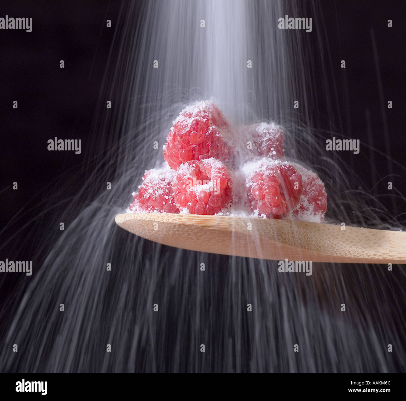 Raspberries being sprinkled with sugar Stock Photo