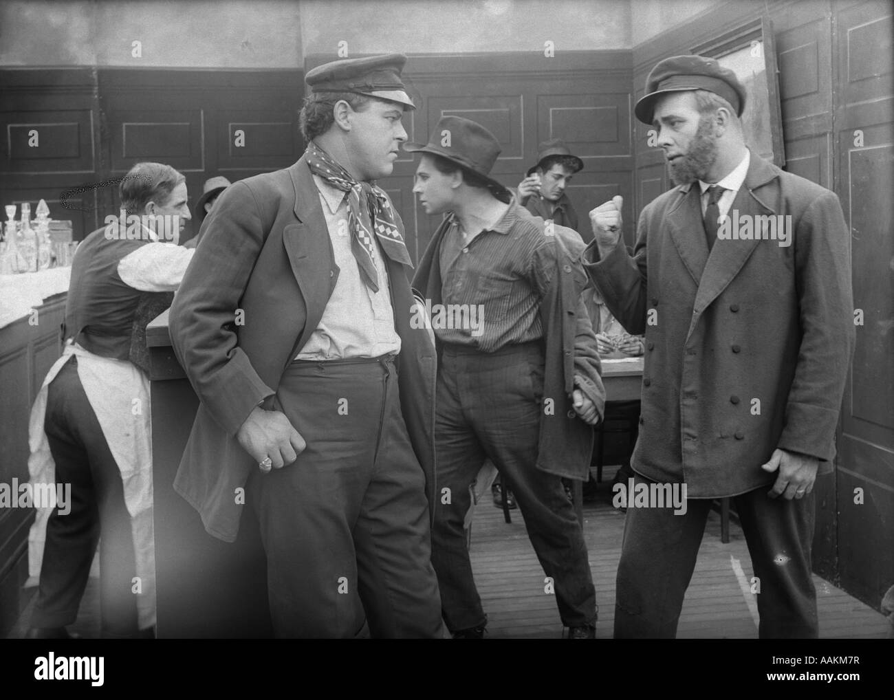 1910s MEN IN SEAPORT SALOON ABOUT TO ENGAGE IN BAR FIGHT SILENT MOVIE STILL Stock Photo