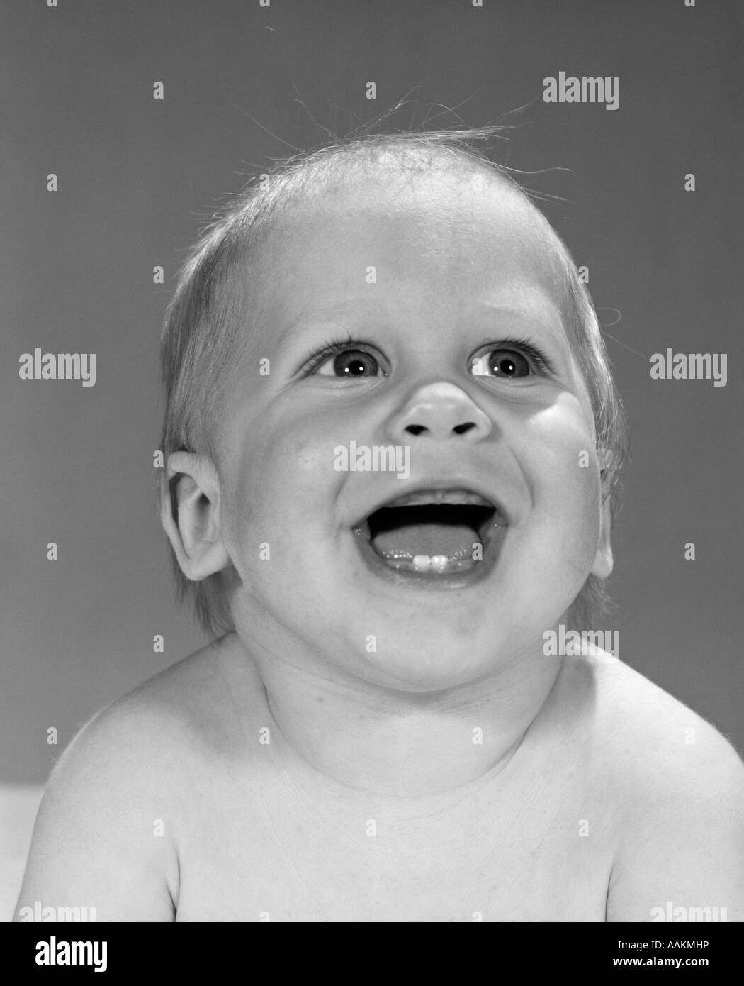 1960s PORTRAIT CLOSE-UP OF SMILING BABY BOY SHOWING FIRST TWO TEETH IN BOTTOM GUMS Stock Photo