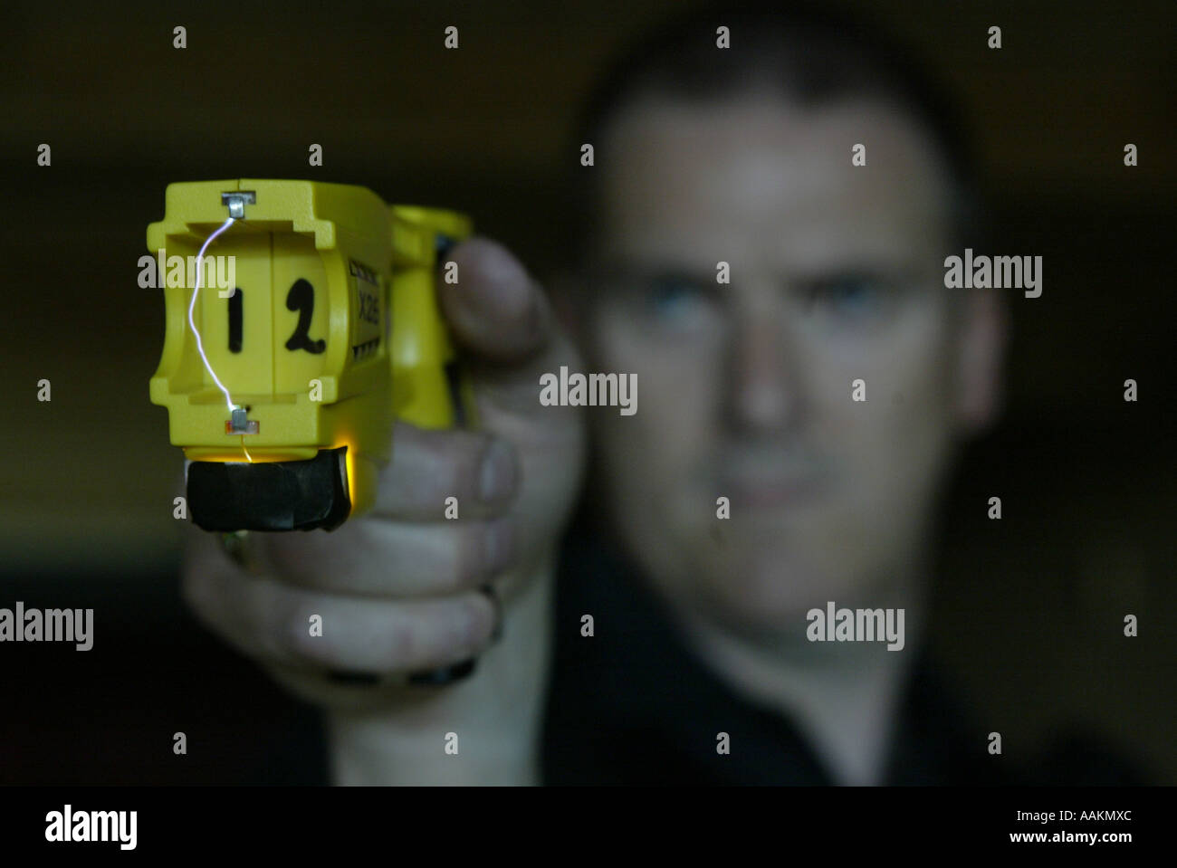 A MAN DEMONSTRATES A TASER STUN GUN USED BY POLICE IN THE UK Stock Photo