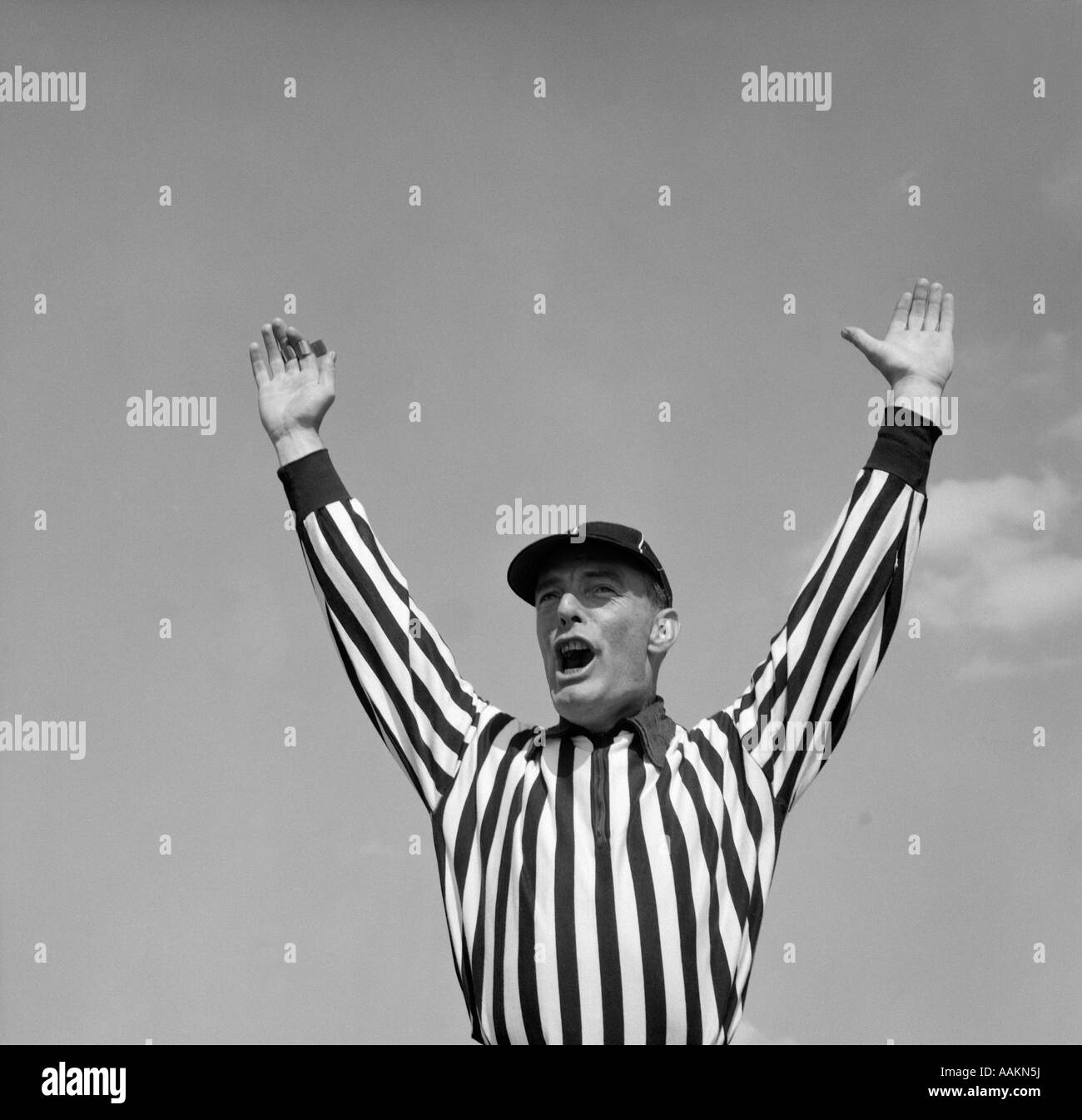 1950s FOOTBALL REFEREE MAKING TOUCHDOWN SIGNAL Stock Photo