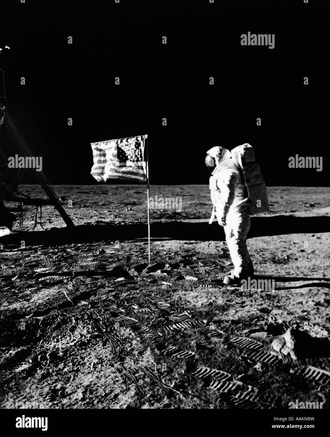 1969 ASTRONAUT U.S. FLAG AND LEG OF LUNAR LANDER ON THE SURFACE OF THE MOON Stock Photo