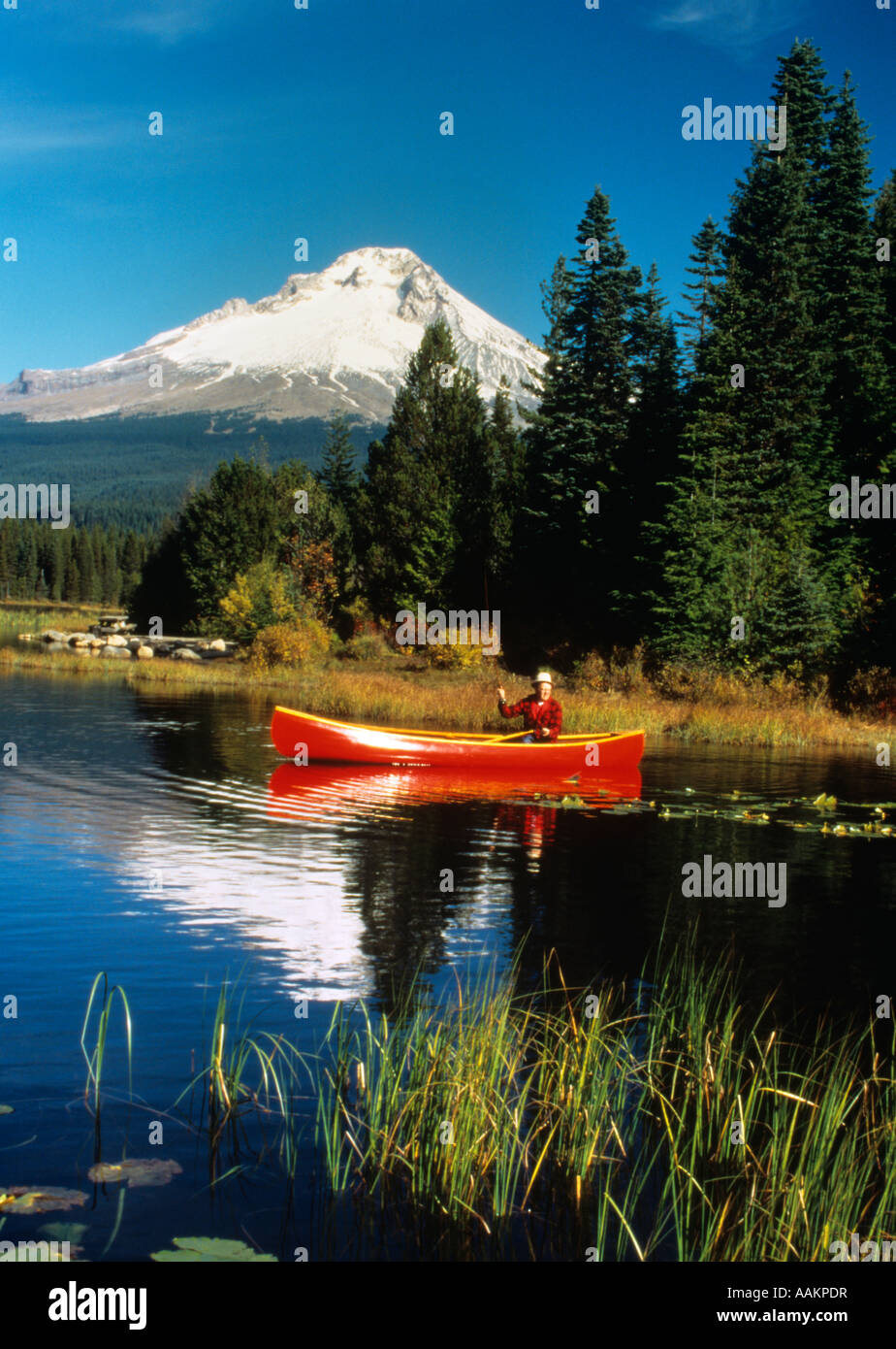 MAN FISHING FROM RED CANOE MOUNT HOOD OREGON TRILLIUM LAKE Stock Photo