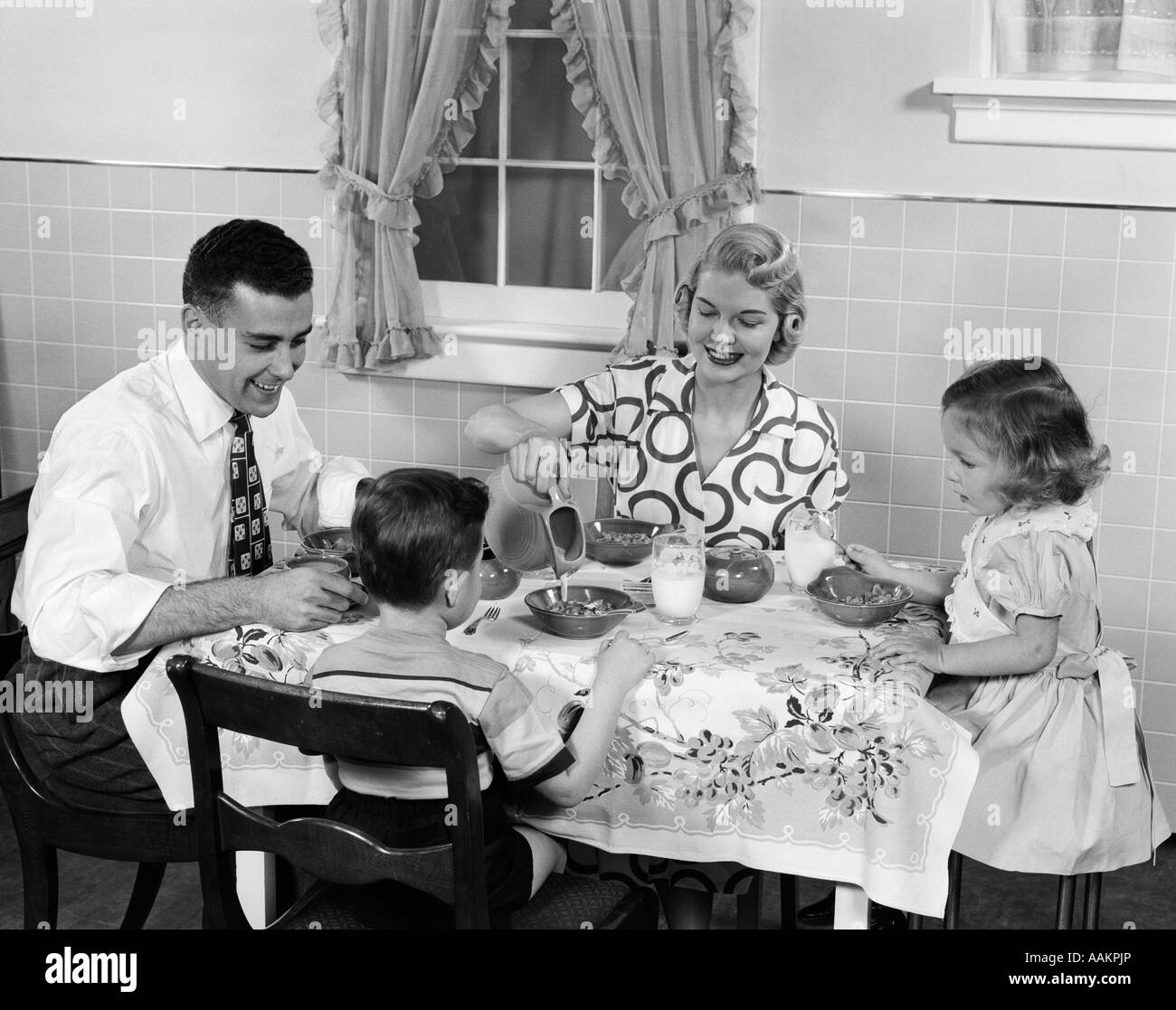 1950s FAMILY SITTING AT KITCHEN TABLE HAVING BREAKFAST Stock Photo