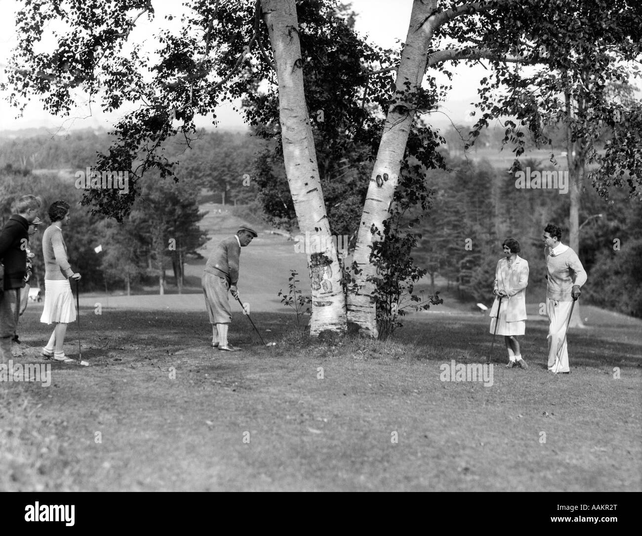 1920s 1930s GROUP OF GOLFERS UNDER BIRCH TREE IN THE ROUGH AT THE PITTSFIELD COUNTRY CLUB BERKSHIRE MOUNTAINS MASSACHUSETTS Stock Photo