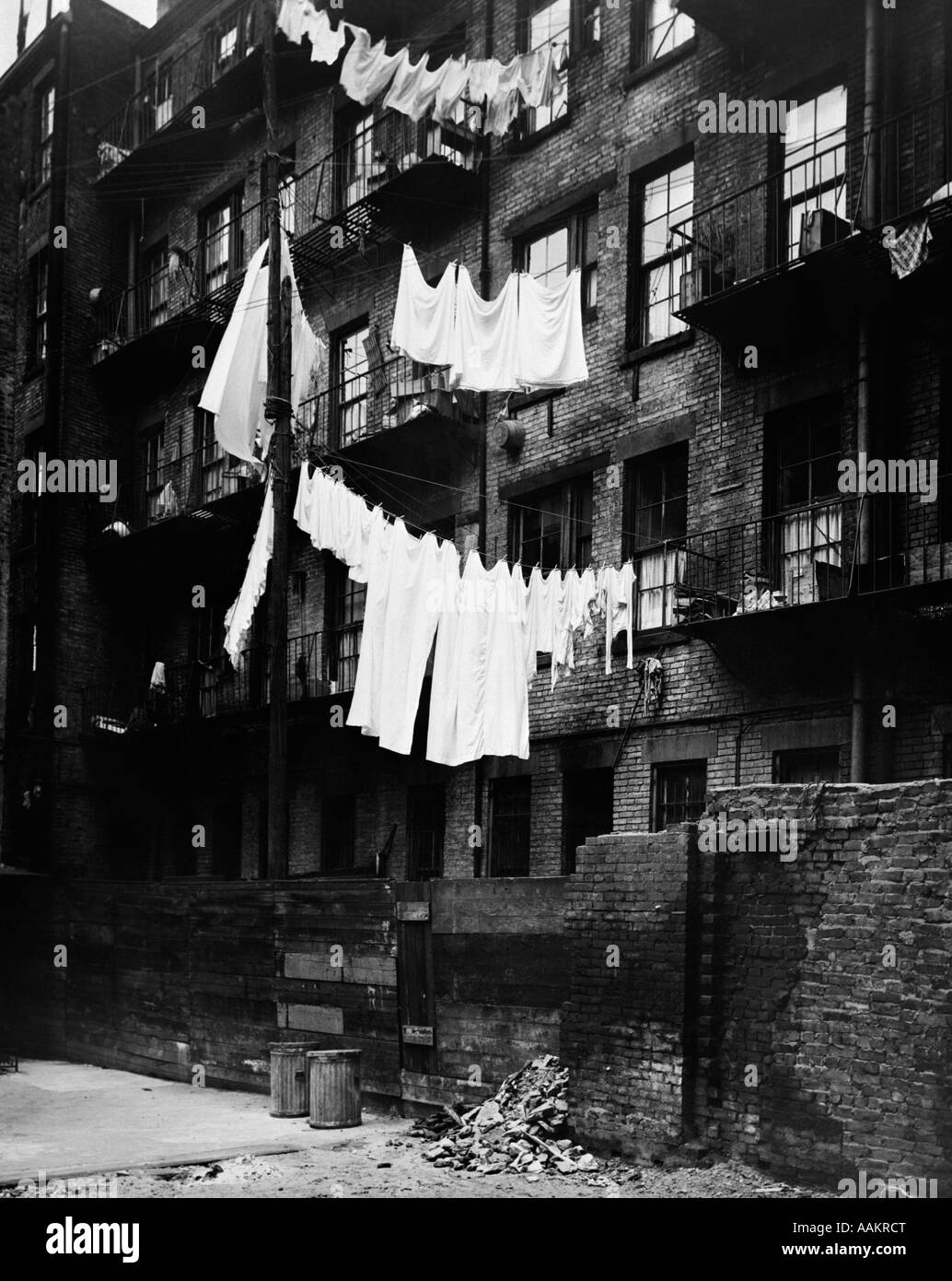 1930s TENEMENT BUILDING WITH LAUNDRY HANGING ON CLOTHESLINES I Stock Photo
