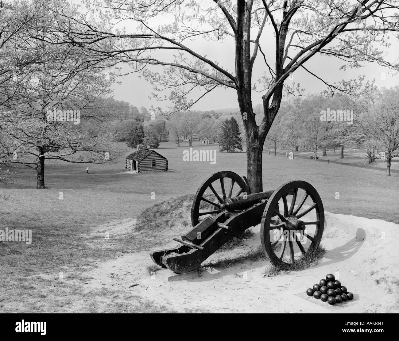 OVERVIEW OF LANDSCAPE AT VALLEY FORGE WITH CANNON IN FOREGROUND & CABIN IN BACKGROUND Stock Photo