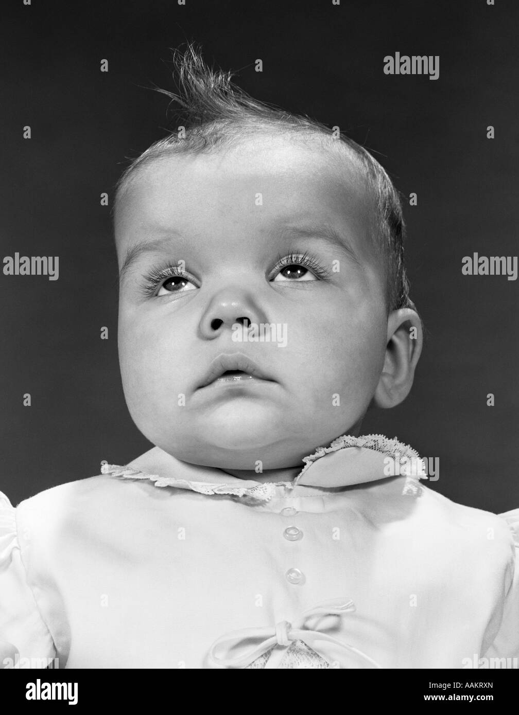 BABY PORTRAIT WEAR DRESS BUTTONS BOW COLLAR FACE EXPRESSION ABOUT TO CRY SAD Stock Photo