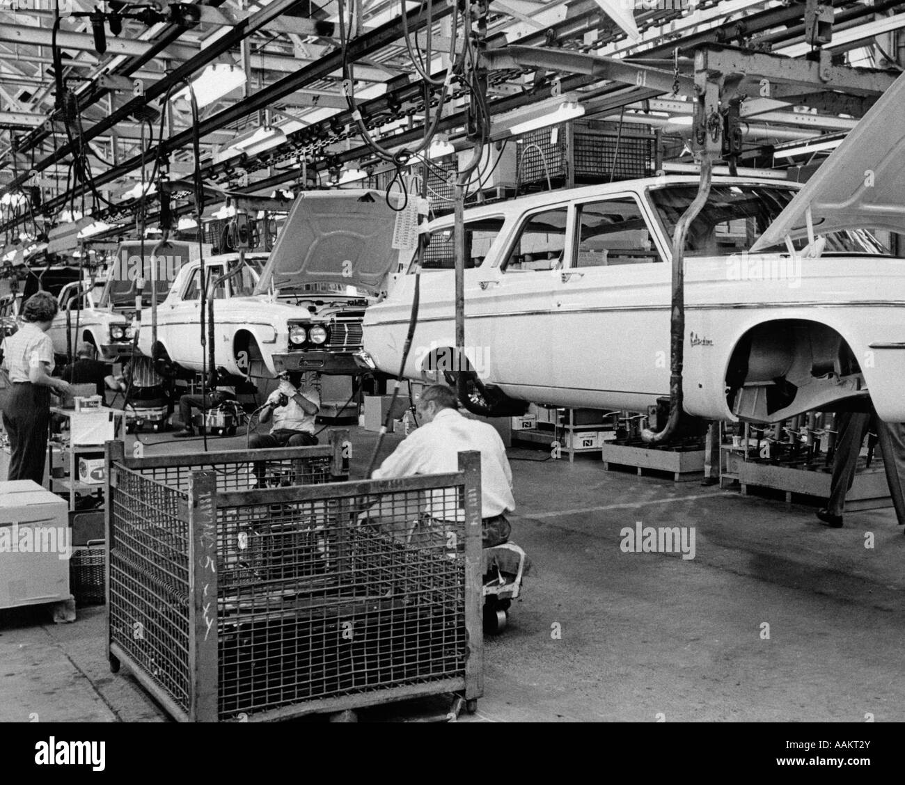 1960s CHRYSLER ASSEMBLY LINE WITH CAR BODIES ELEVATED FOR EMPLOYEES TO