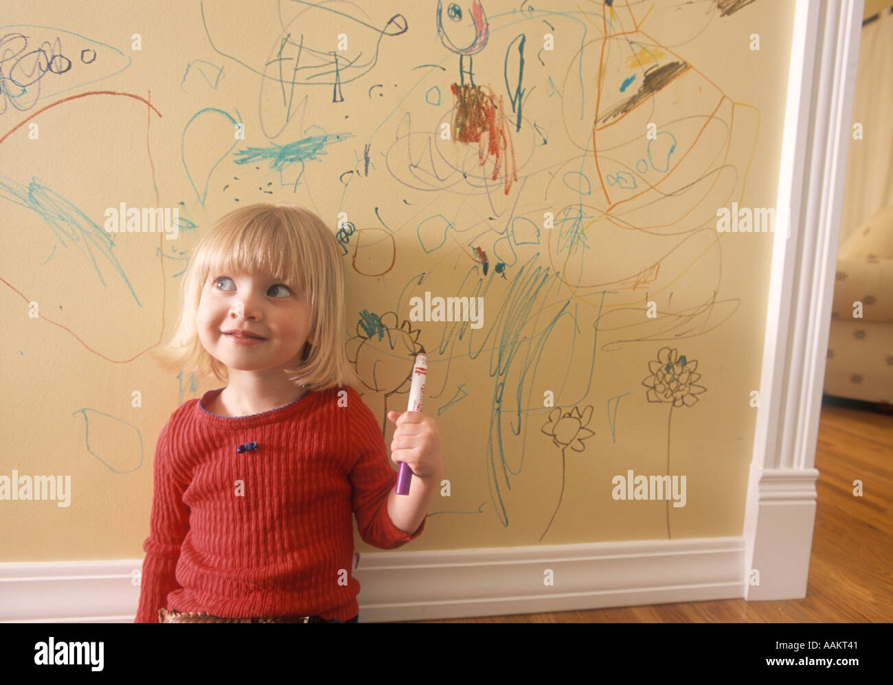 little girl writing on the wall of her house Stock Photo Alamy