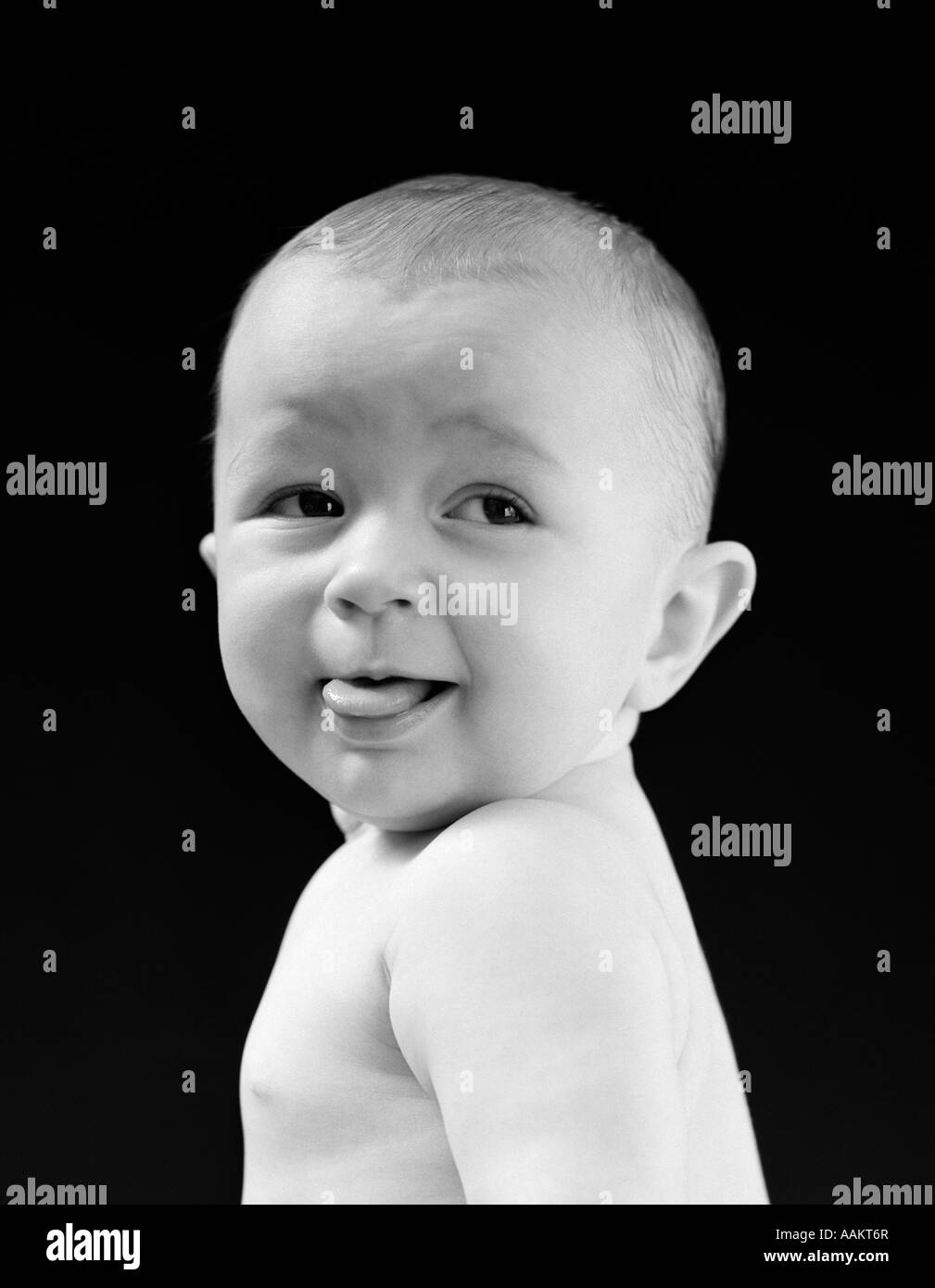 1940s 1950s BABY HEAD & SHOULDERS SMILING STICKING OUT TONGUE Stock Photo