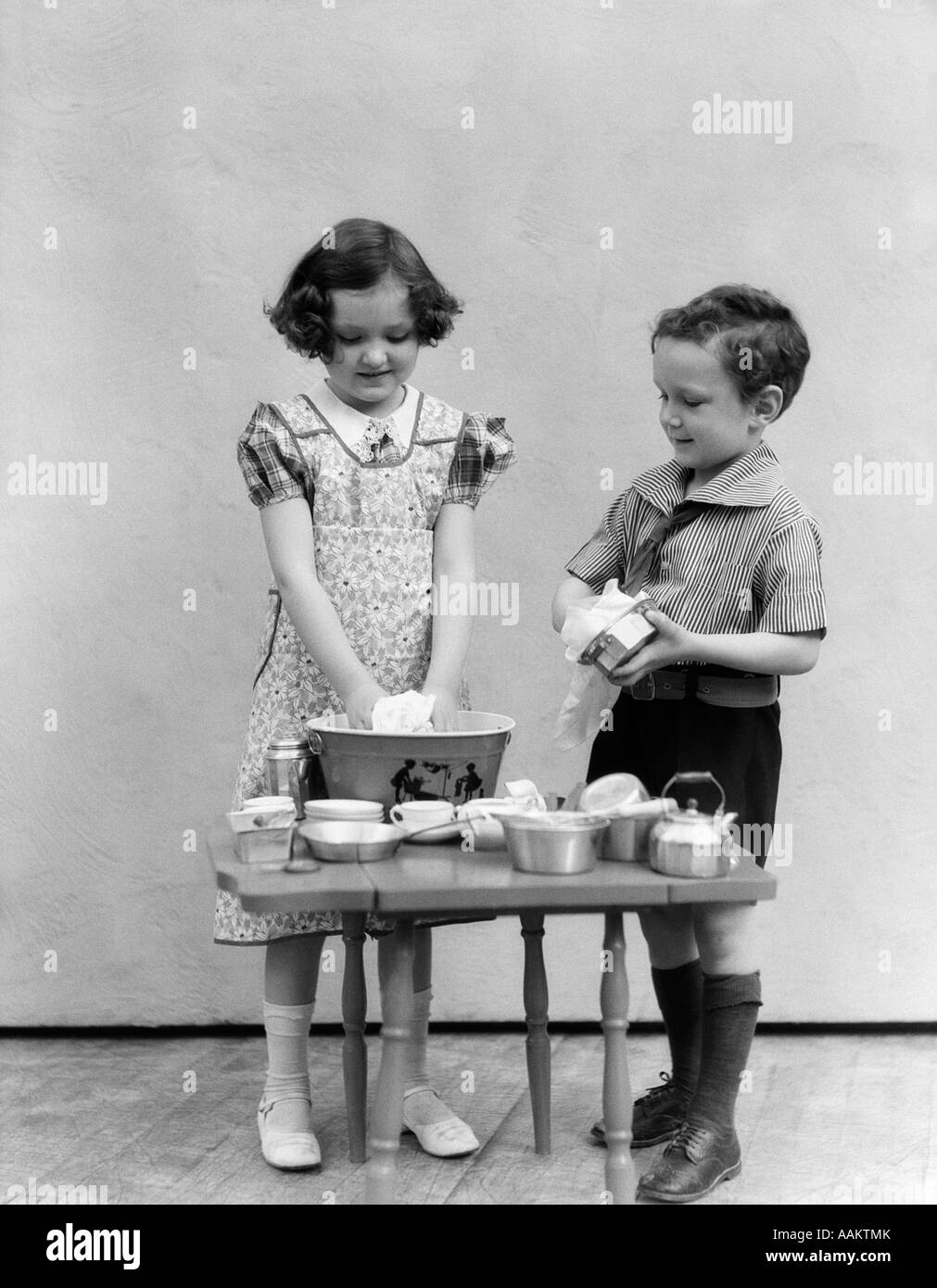 1930s 1940s GIRL WASHING TOY DISHES SMALL BASIN BOY DRYING DISH TOYS TEA  SET CHORES HOUSEHOLD PLAYING HOUSE Stock Photo - Alamy