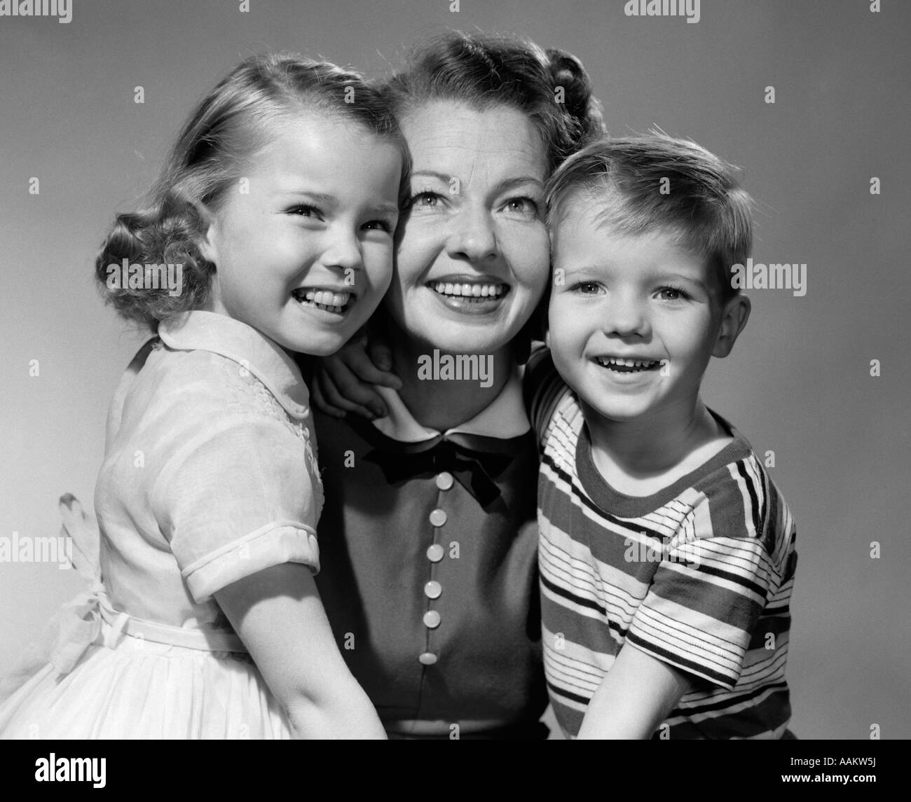1950s SMILING PORTRAIT MOTHER TWO KIDS CHILDREN BOY GIRL SON DAUGHTER Stock Photo