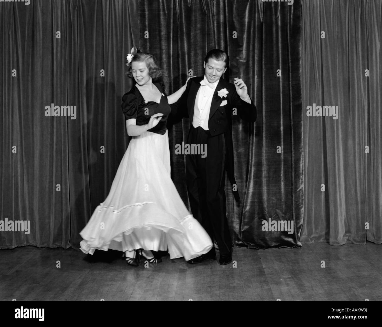 1940s COUPLE MAN AND WOMAN IN FORMAL WEAR BALLROOM DANCING ON STAGE Stock Photo