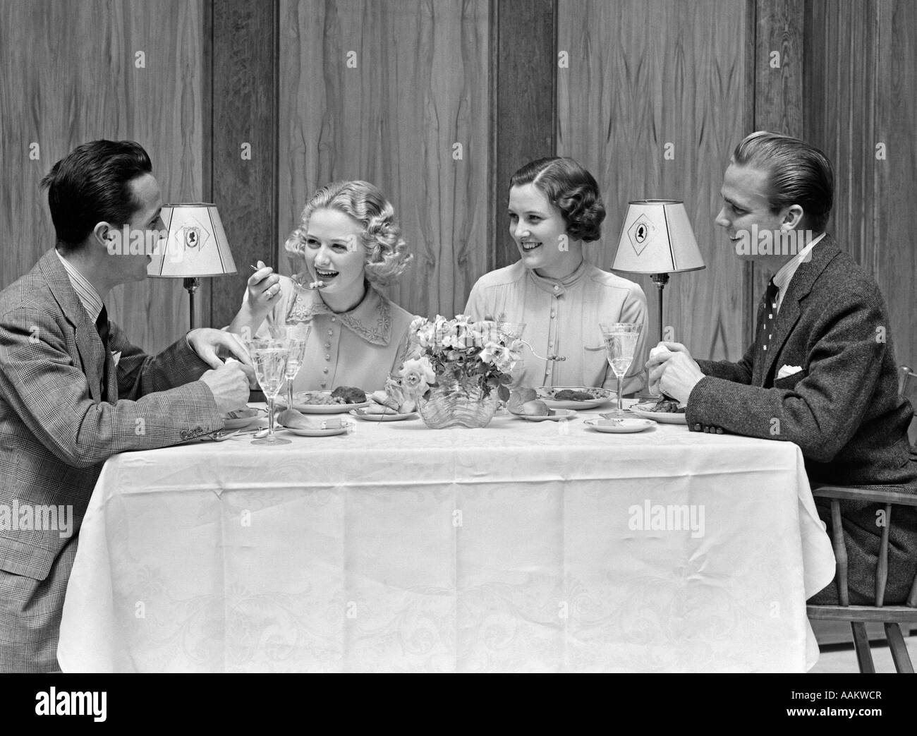 1930s 1940s TWO COUPLES DINING AT RESTAURANT TABLE Stock Photo