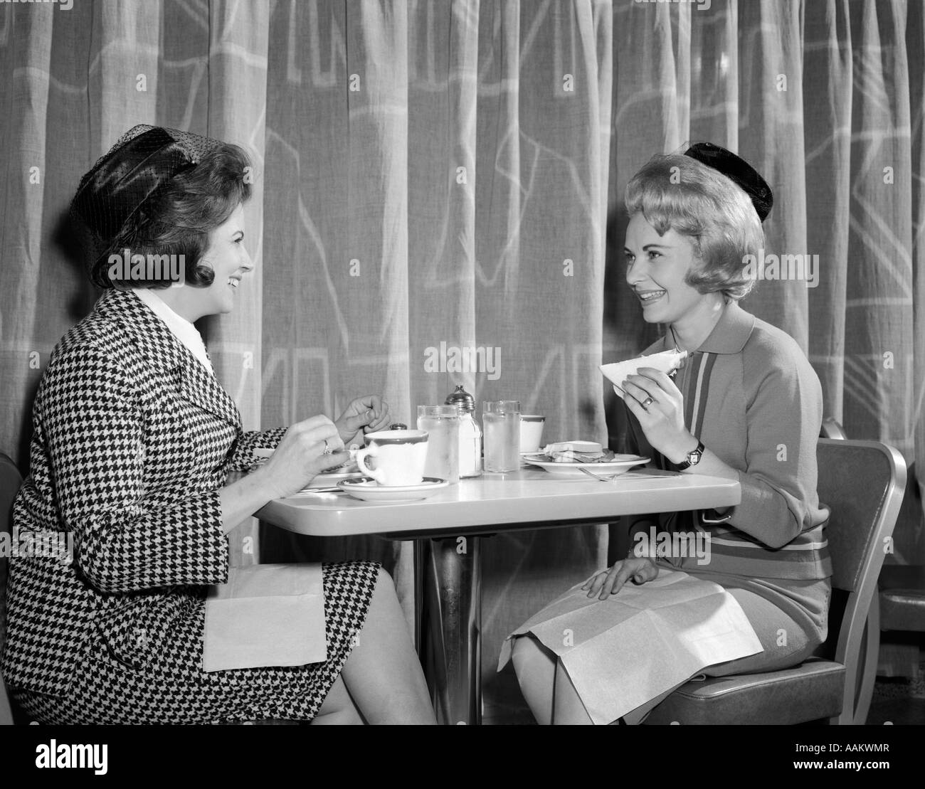 1960s TWO WOMEN HAVING LUNCH IN COFFEE SHOP RESTAURANT Stock Photo