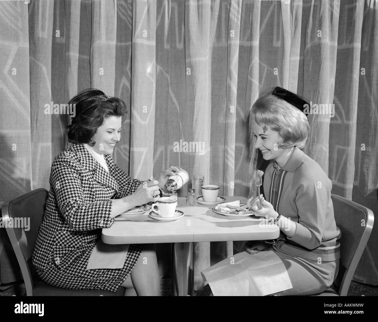 1960s TWO WOMEN HAVING LUNCH IN COFFEE SHOP RESTAURANT Stock Photo