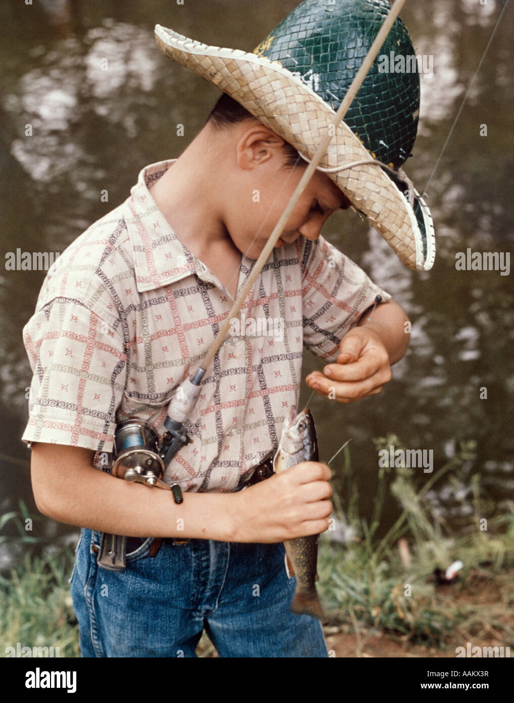 BOY WEARING STRAW HAT REMOVING HOOK FROM MOUTH OF FISH OUTDOOR Stock Photo  - Alamy