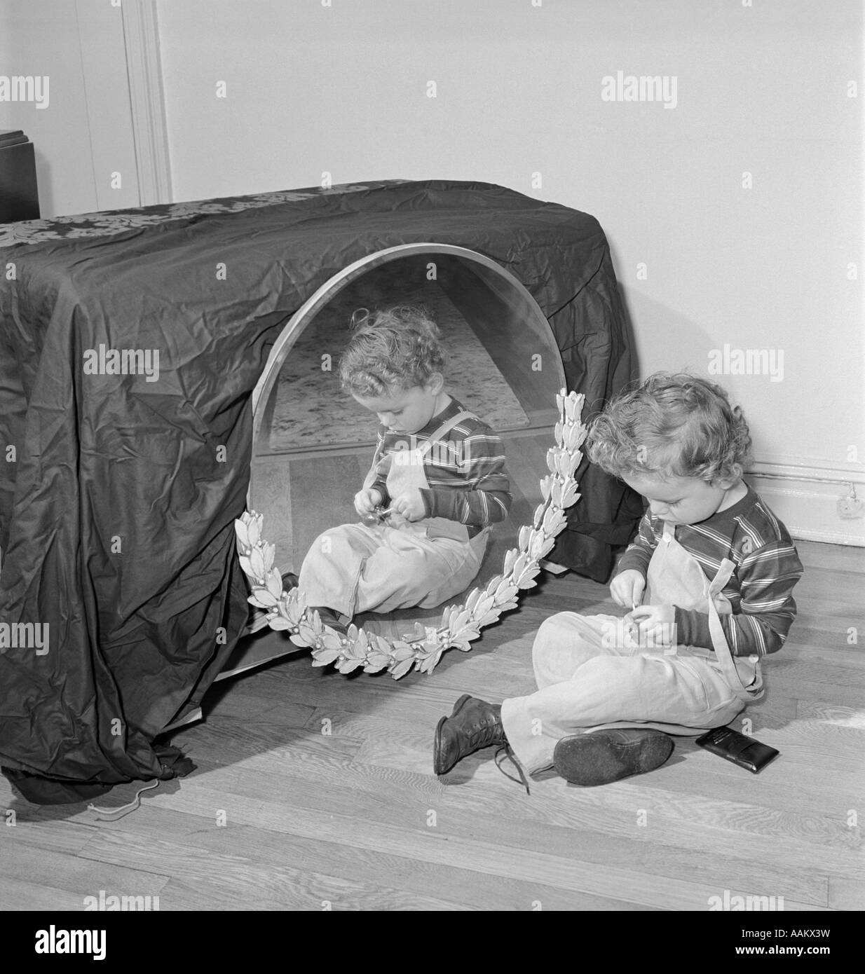 1950s SMALL BOY SITTING ON FLOOR BEFORE MIRROR PLAYING WITH TRINKET Stock Photo