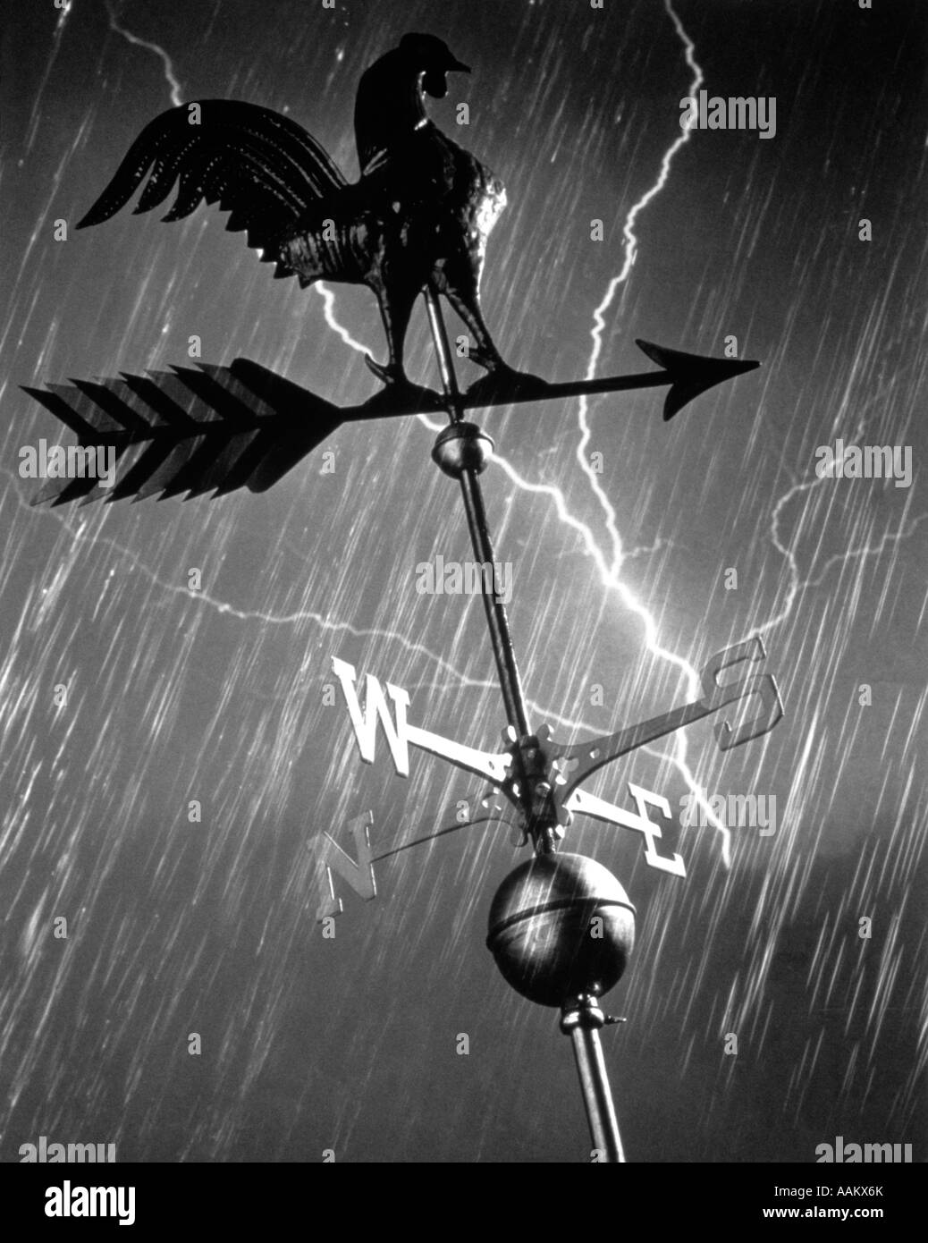 ROOSTER WEATHERVANE IN RAIN AND LIGHTNING STORM Stock Photo