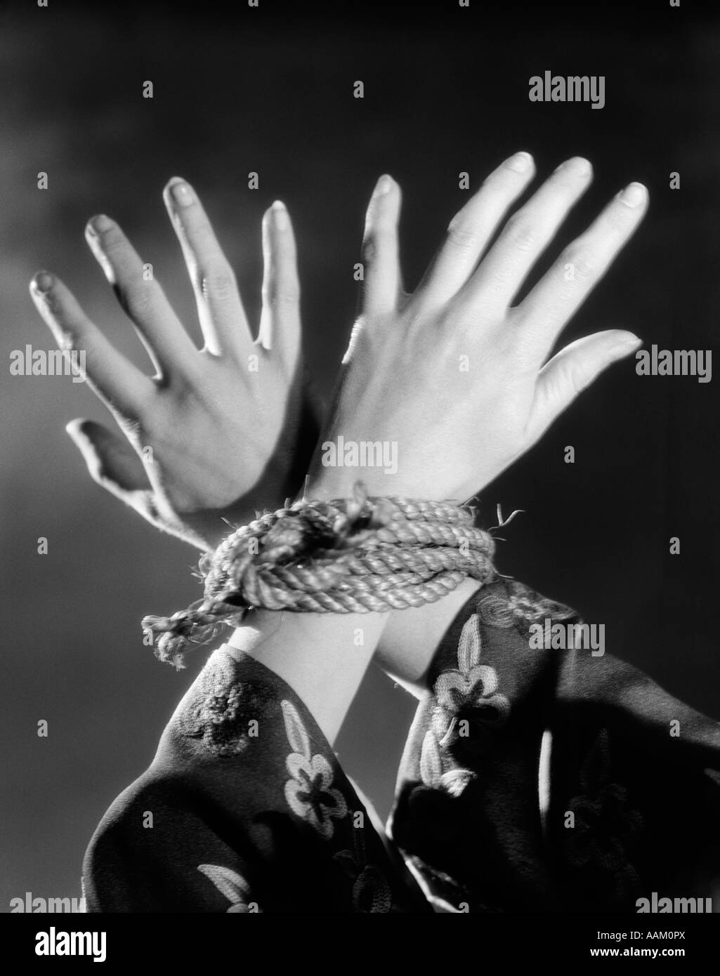 1930s WOMAN'S HANDS TIED TOGETHER BY ROPE OVERHEAD VIEW Stock Photo