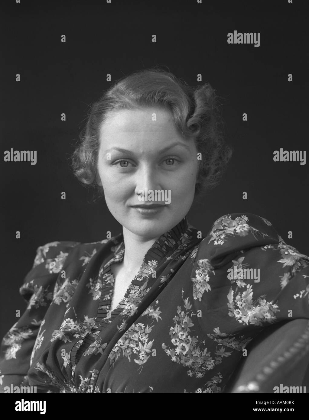 1930s 1940s MIDDLE AGED WOMAN PORTRAIT LOOKING AT CAMERA FLORAL PRINT DRESS Stock Photo