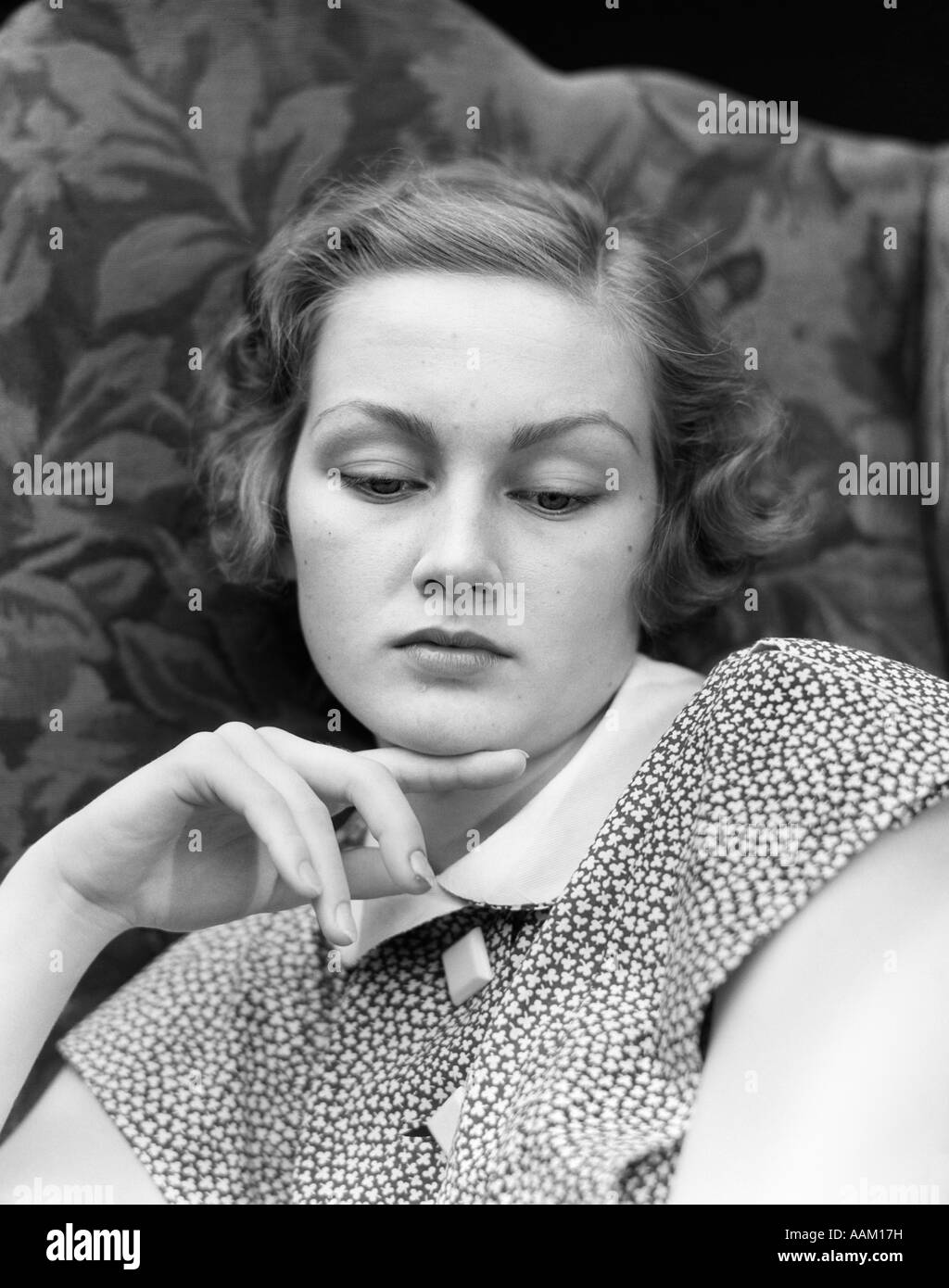 1930s PORTRAIT OF WOMAN LOOKING DOWN WITH SAD EXPRESSION AND HER CHIN RESTING ON INDEX FINGER Stock Photo