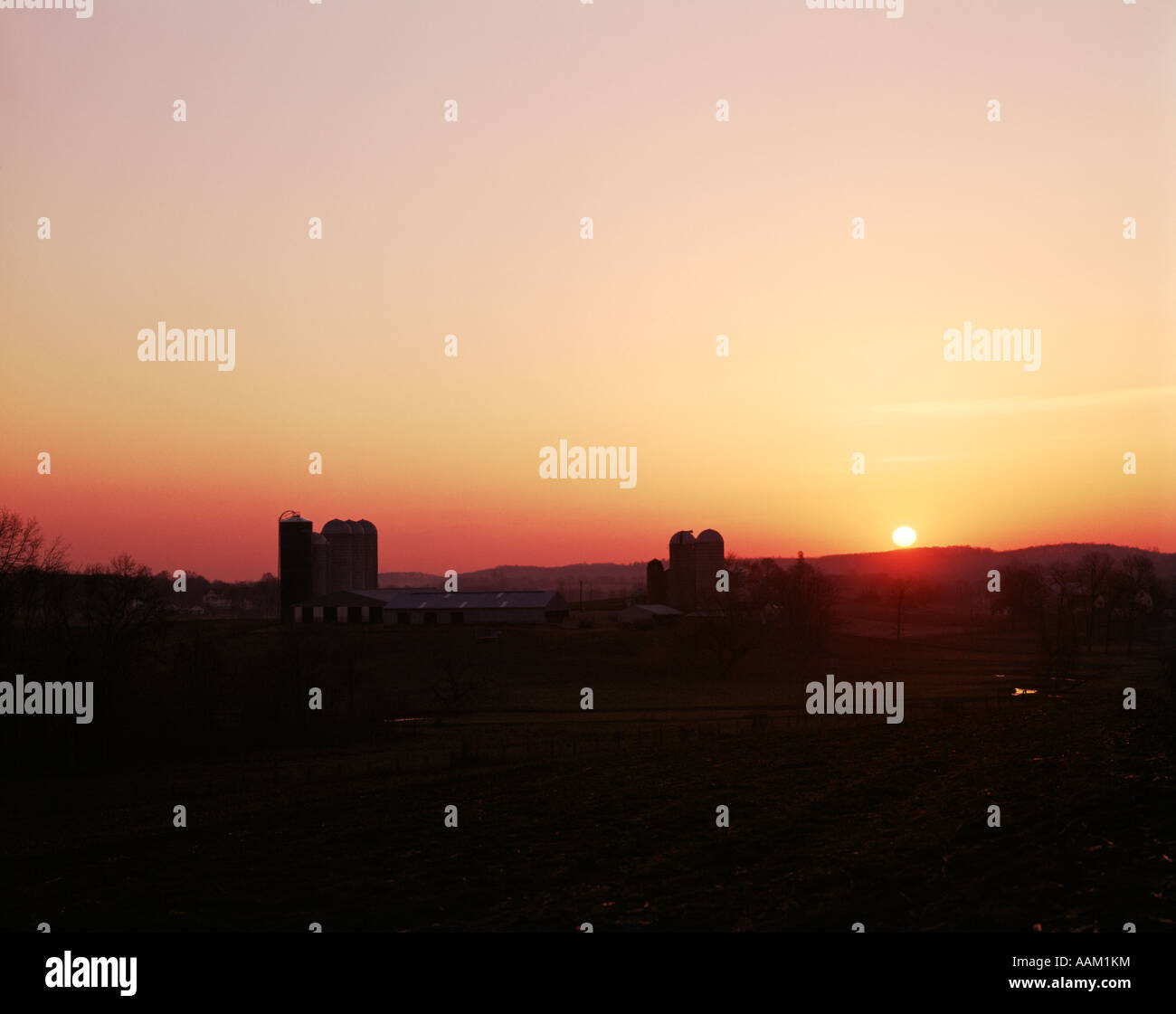 GOLDEN SUNSET SUNRISE OVER FARMLAND SCENIC LANDSCAPE SILOS SILHOUETTED CHESTER COUNTY PENNSYLVANIA USA Stock Photo