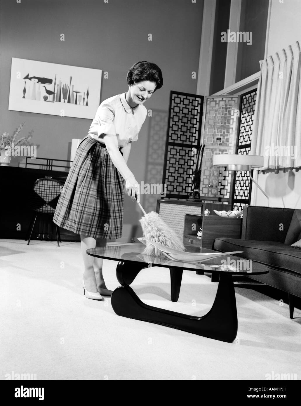 1950s WOMAN WEARING A WHITE BLOUSE & PLAID SKIRT DUSTING WITH A FEATHER  DUSTER A GLASS TOP COFFEE TABLE Stock Photo - Alamy