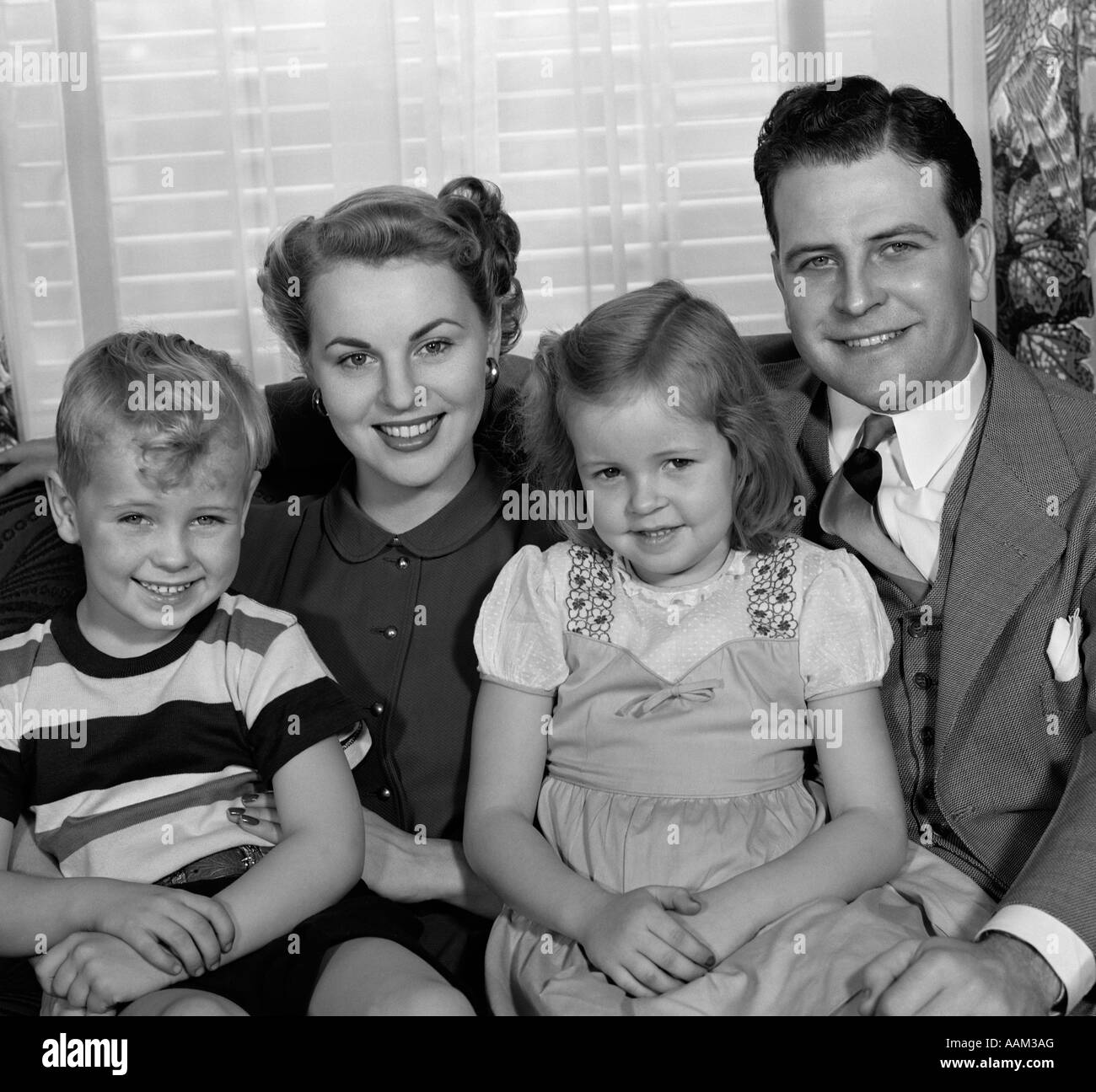1940s 1950s Portrait Of Smiling Family Man Woman Boy Girl Sitting