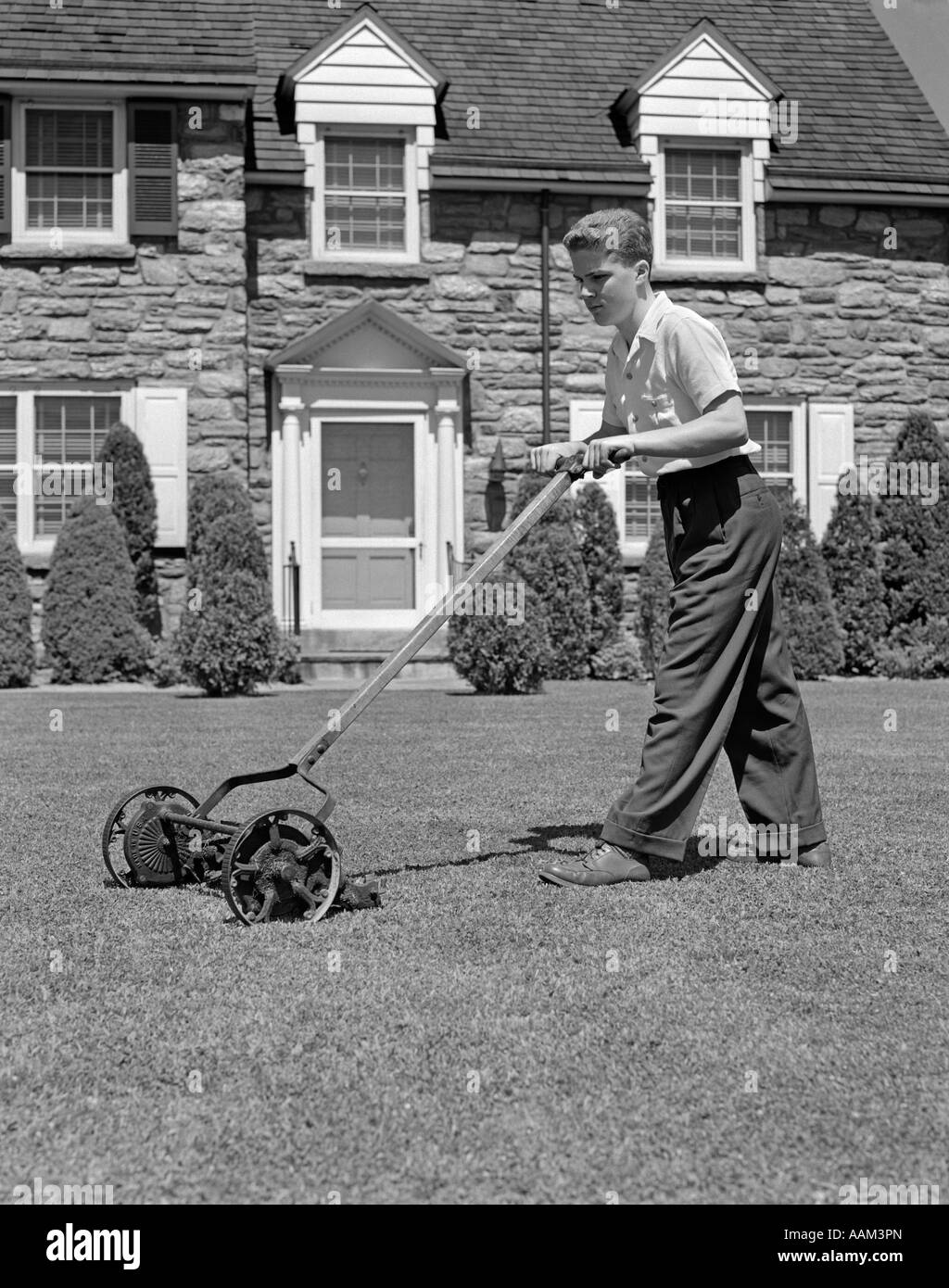 https://c8.alamy.com/comp/AAM3PN/1940s-teen-boy-mowing-grass-pushing-mower-in-front-lawn-of-stone-suburban-AAM3PN.jpg