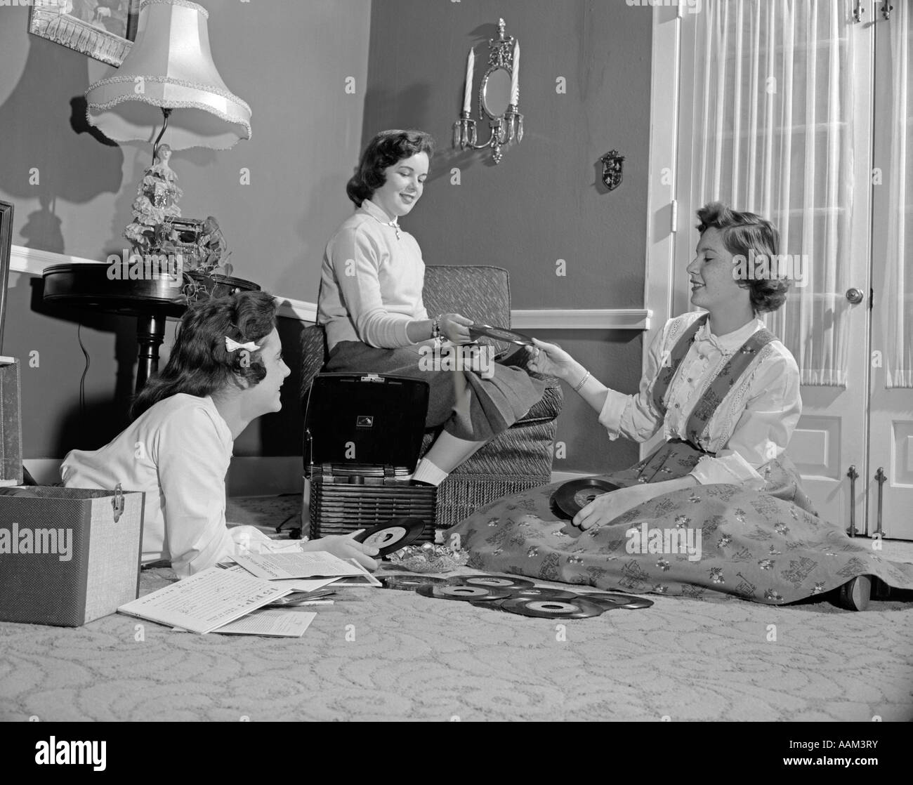 1950s THREE TEEN GIRLS TALKING LISTENING TO MUSIC PLAYING 45RPM RECORDS PORTABLE PHONOGRAPH RECORD PLAYER Stock Photo