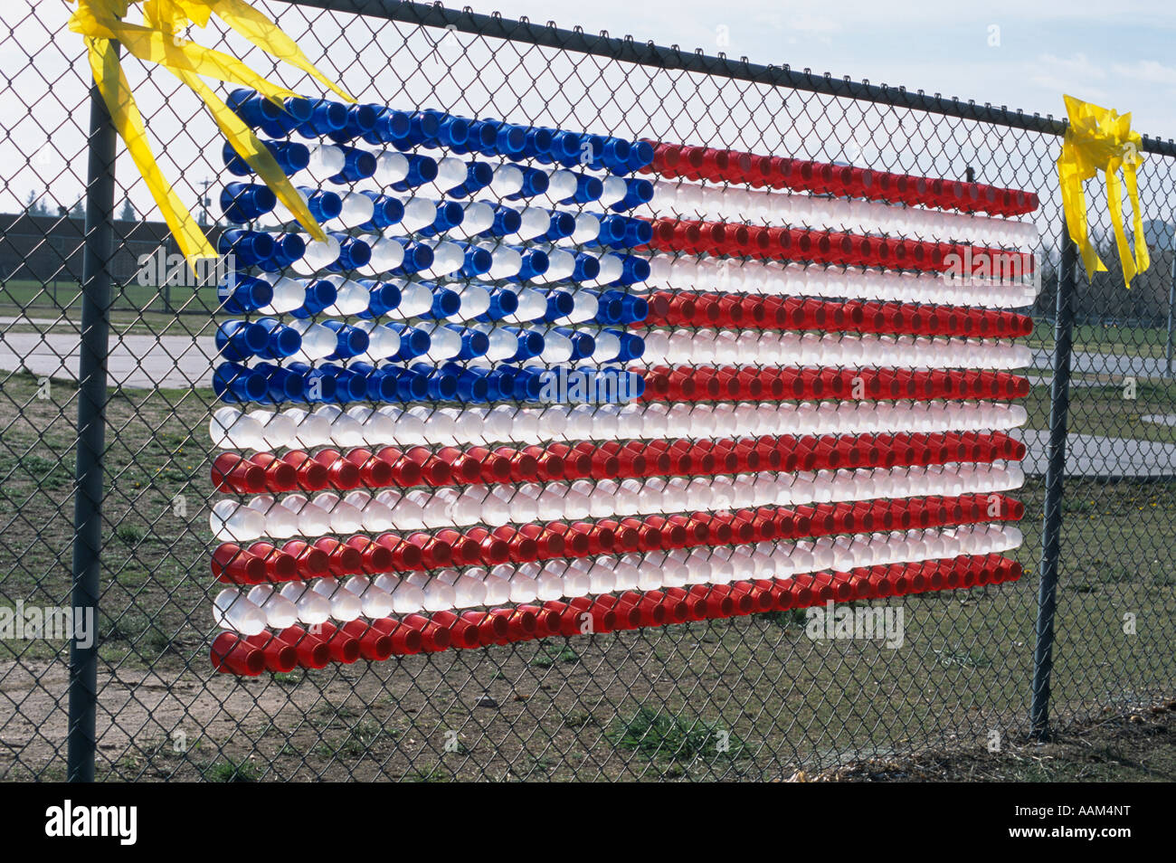 AMERICAN FLAG MADE OF PLASTIC CUPS ON SCHOOLYARD FENCE PATRIOTIC FREEDOM Stock Photo