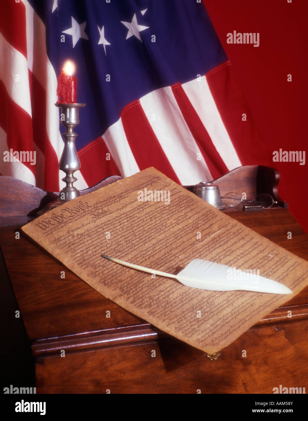 1776 COLONIAL AMERICA FLAG PARCHMENT OF UNITED STATES CONSTITUTION ON DESK QUILL CANDLE PATRIOTIC GOVERNMENT FREEDOM Stock Photo