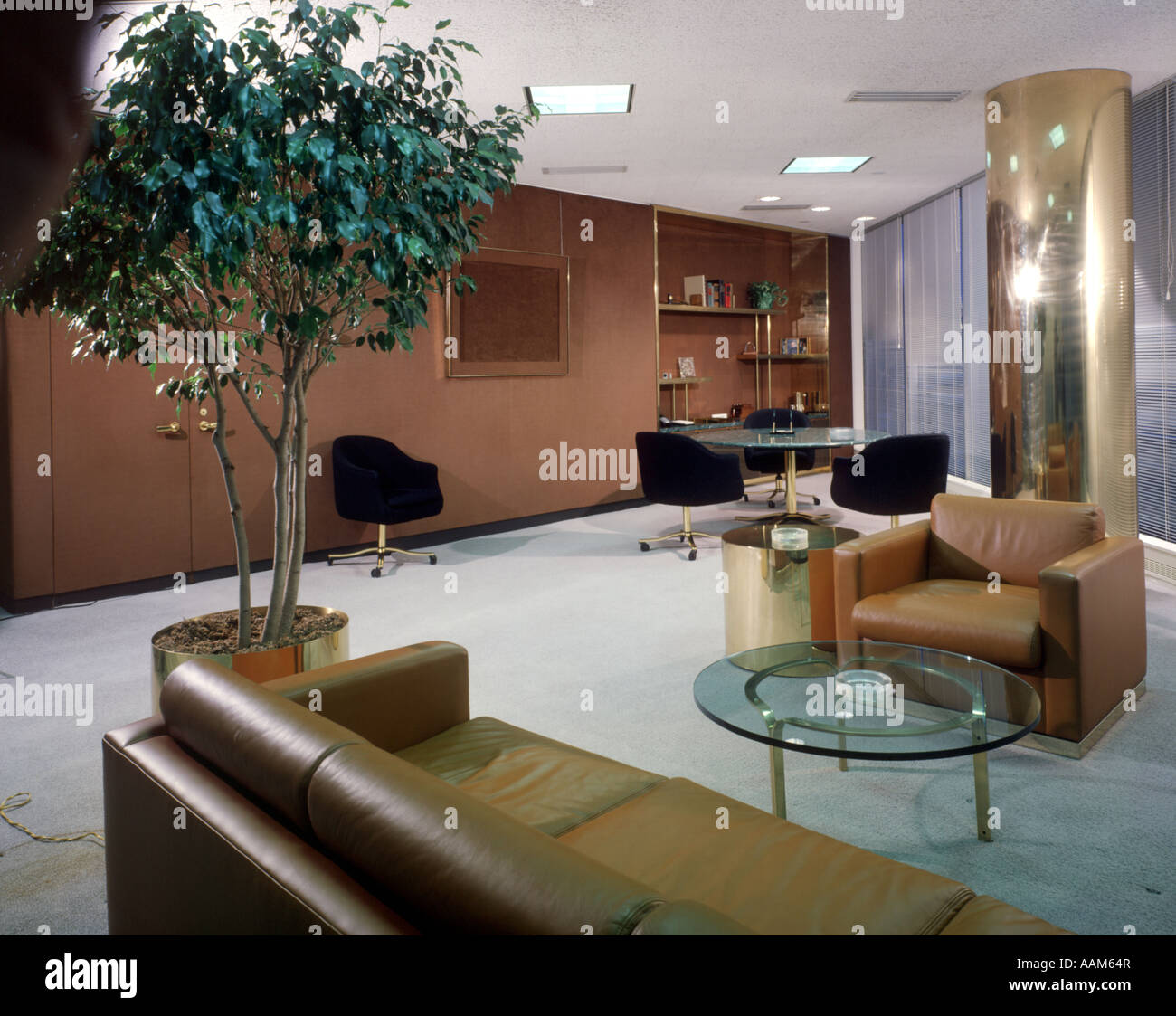 1970 197Os 1980 1980s OFFICE INTERIOR LEATHER COUCH SOFA BROWN GLASS COFFEE TABLE OFFICES FURNITURE HOUSE PLANT Stock Photo