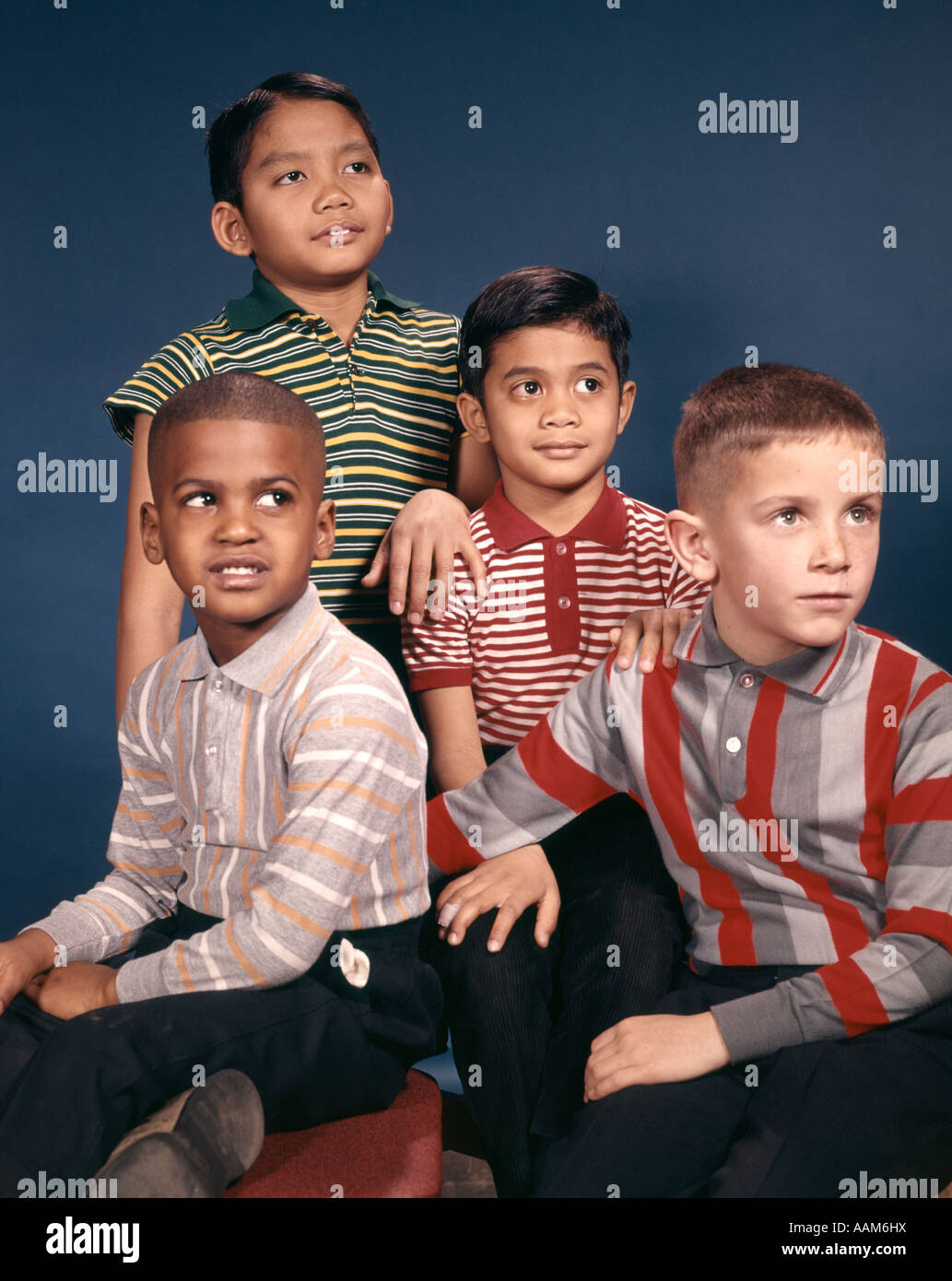 1960s PORTRAIT 4 BOYS IN STRIPED TEE SHIRTS ETHNIC & RACIAL ASIAN HISPANIC AFRICAN-AMERICAN CAUCASIAN Stock Photo