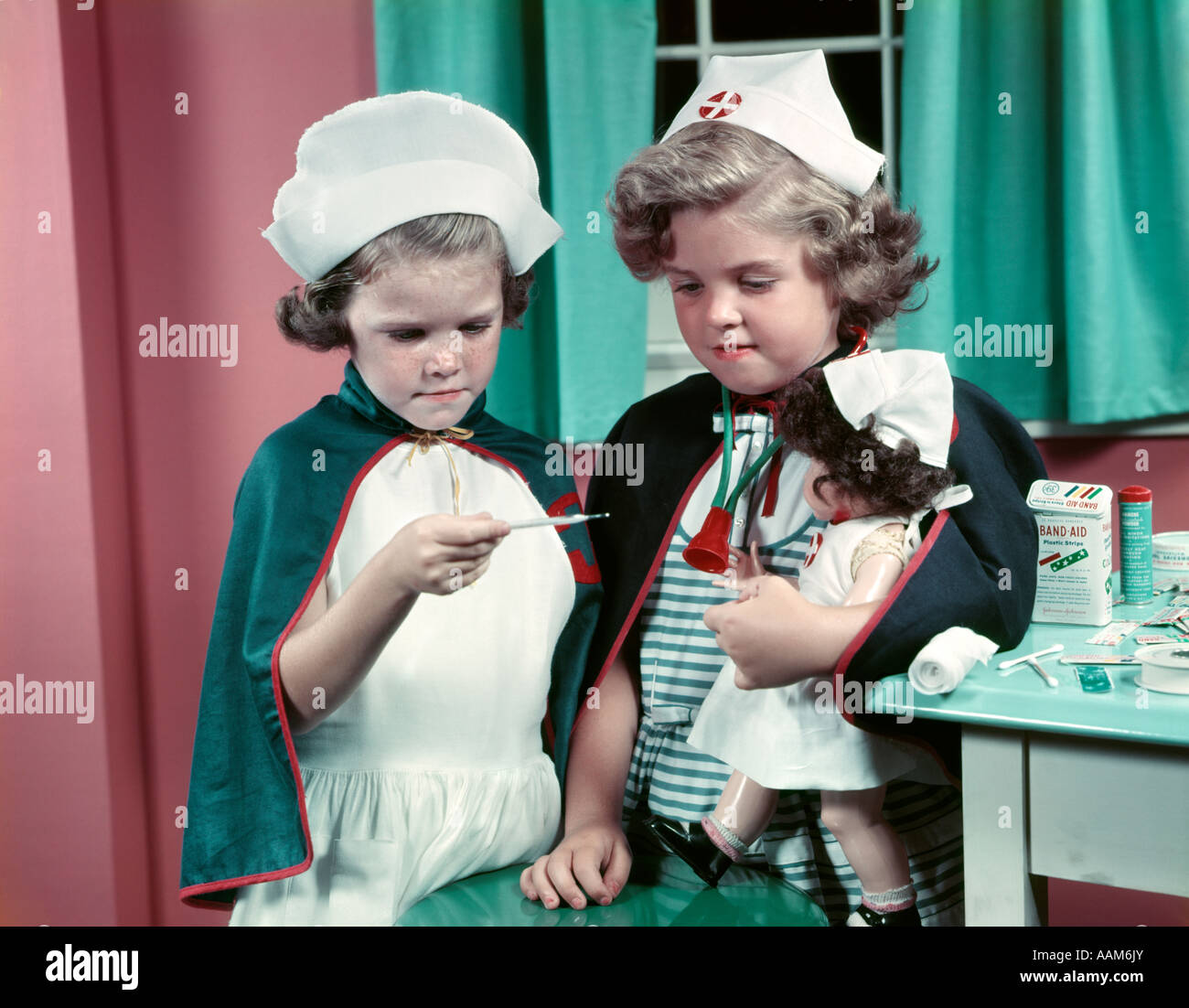 1950s TWO LITTLE GIRLS PLAYING NURSE NOSTALGIA Stock Photo