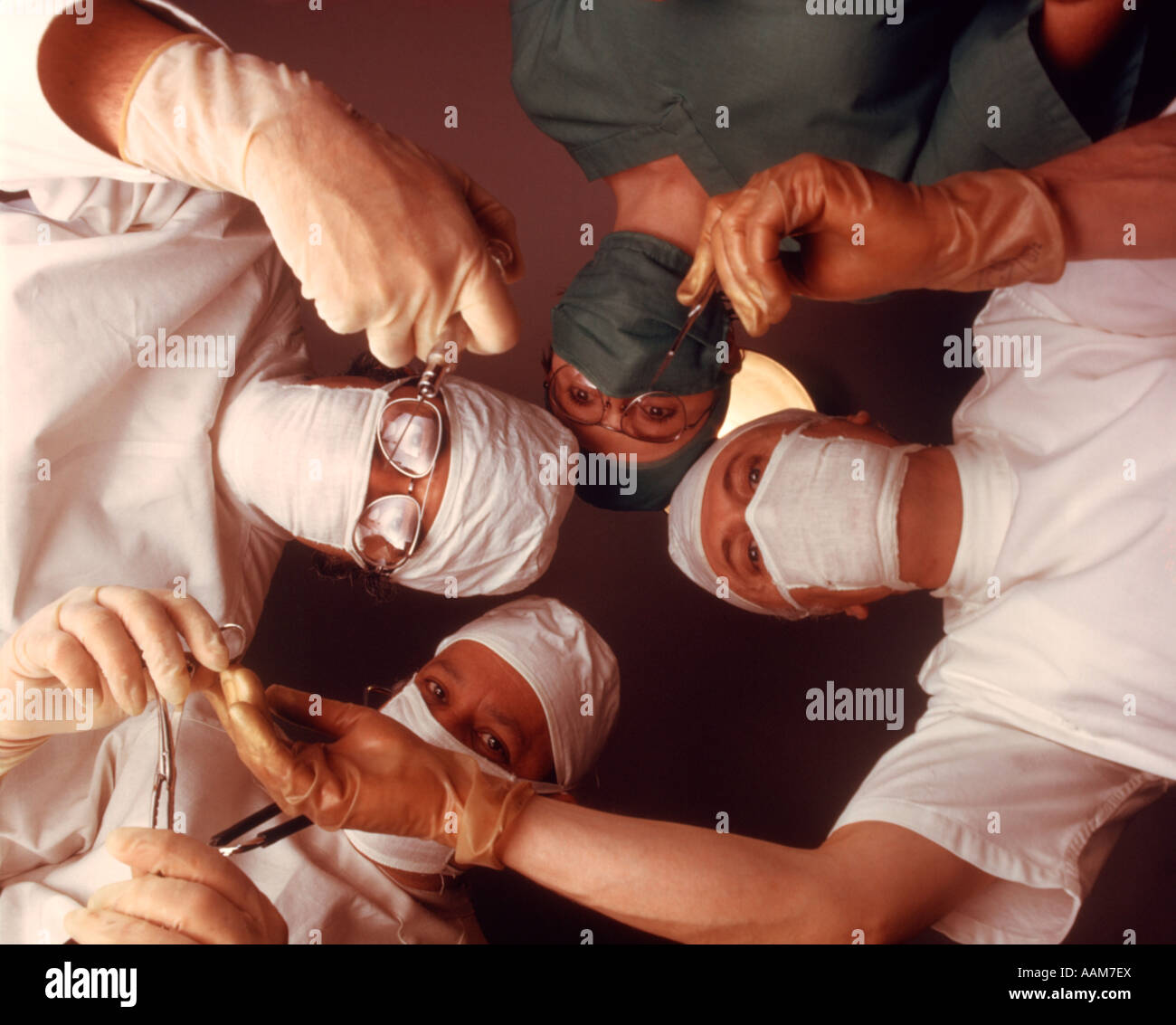 1970 1970s 4 PERSON SURGICAL TEAM FROM BELOW PATIENT POINT OF VIEW DOCTOR NURSE SURGEON DOCTORS SURGERY OPERATION Stock Photo