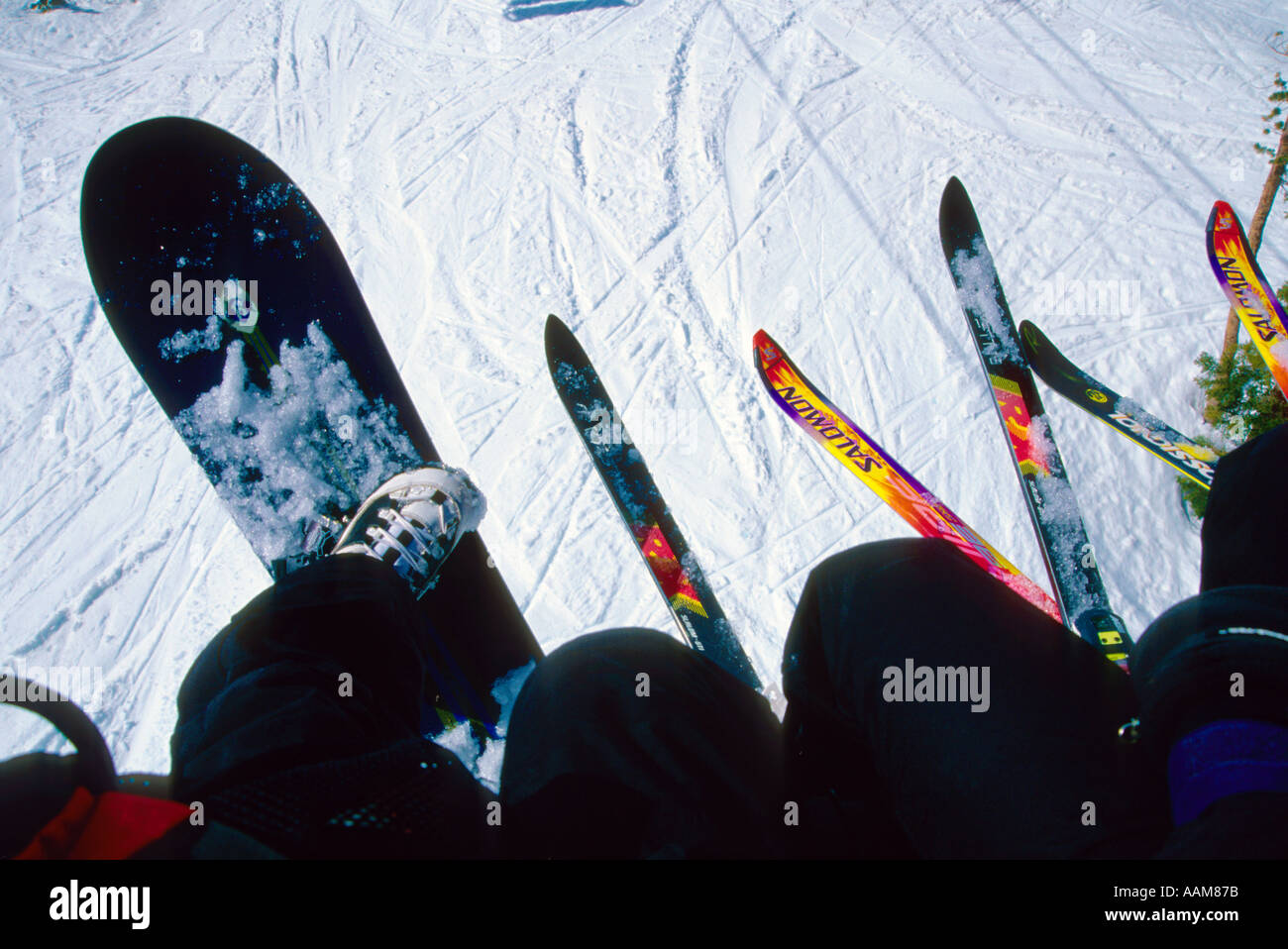 skiiers and snowboarders riding a chair lift at Mammoth Mountain ...