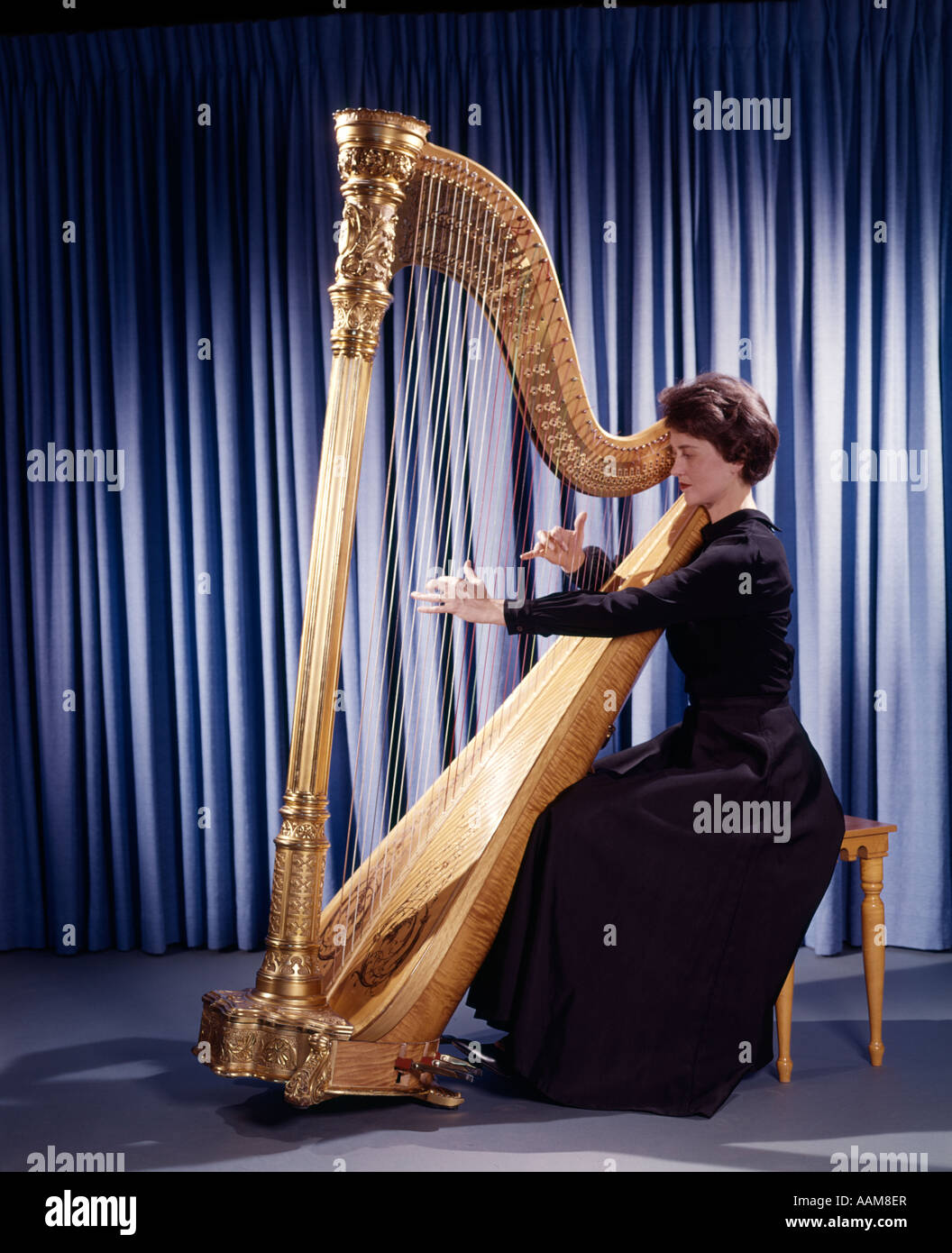 https://c8.alamy.com/comp/AAM8ER/1950s-1960s-1970s-retro-woman-musician-playing-large-classical-harp-AAM8ER.jpg