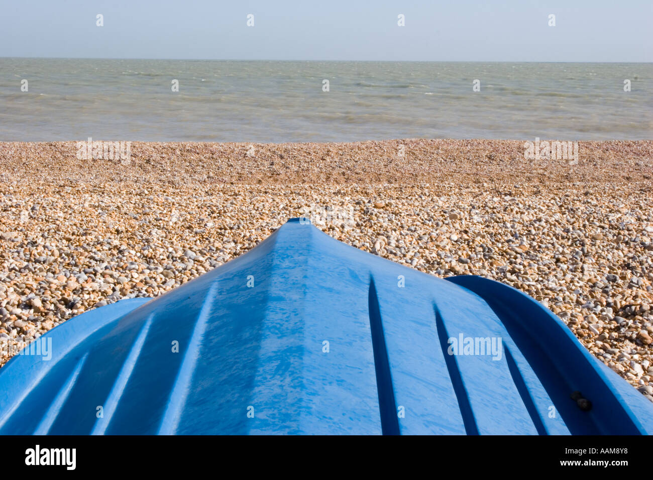 Upturned boat on shingle beach Stock Photo - Alamy