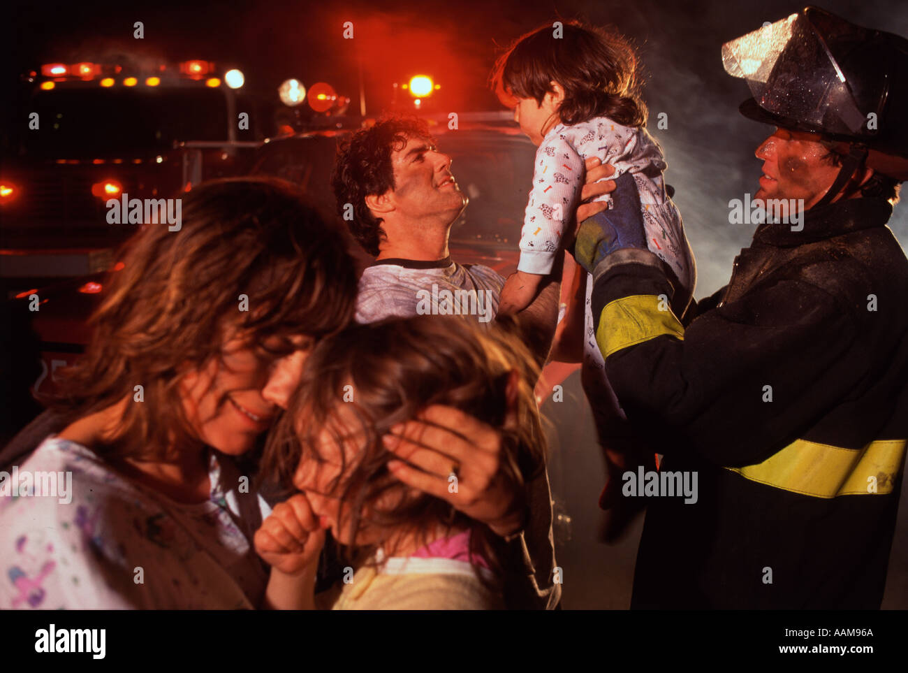 Fireman with family after fire emergency Stock Photo