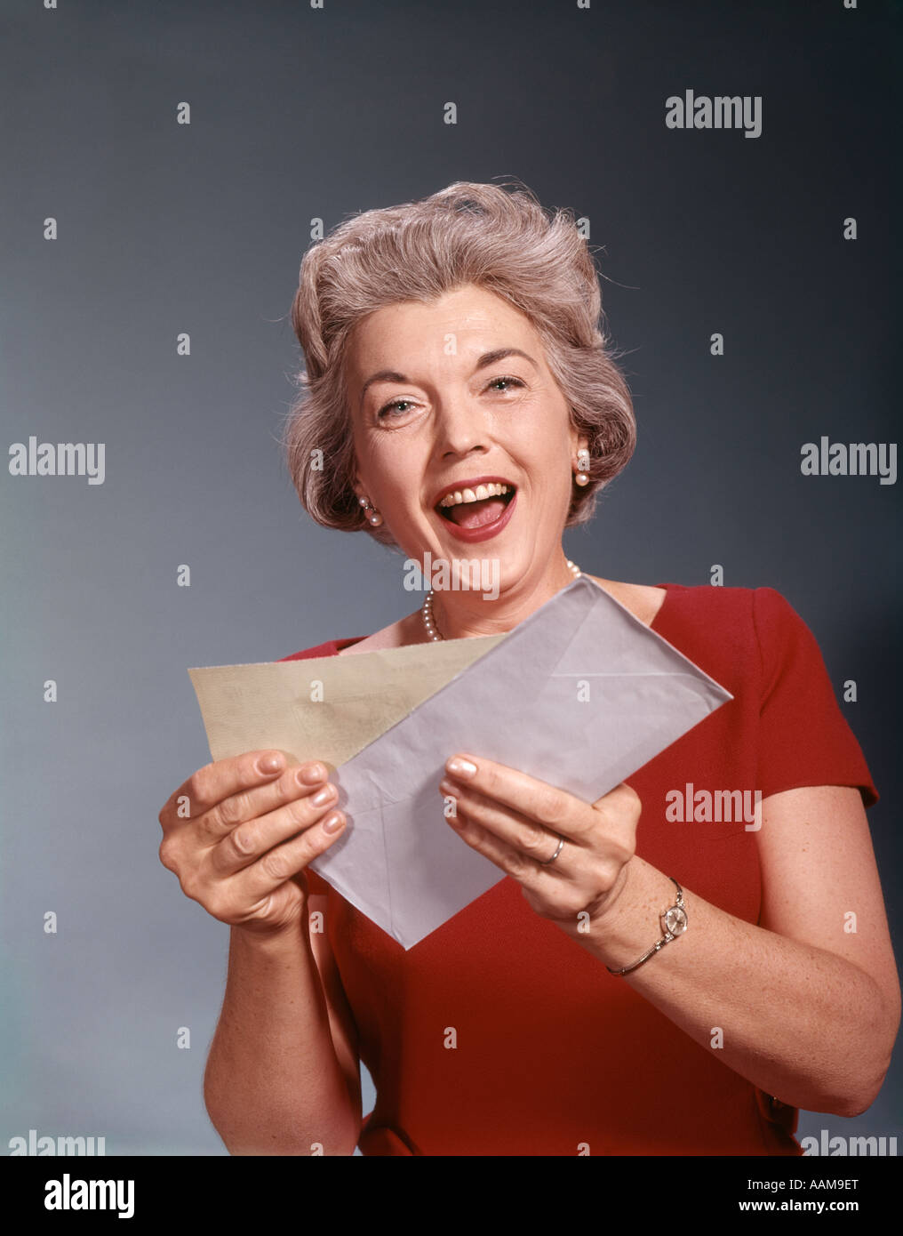 1960s ELDERLY MATURE SENIOR WOMAN OPEN MAIL CHECK LETTER GOOD NEWS SMILING HAPPY RETIREMENT INSURANCE RETRO VINTAGE Stock Photo