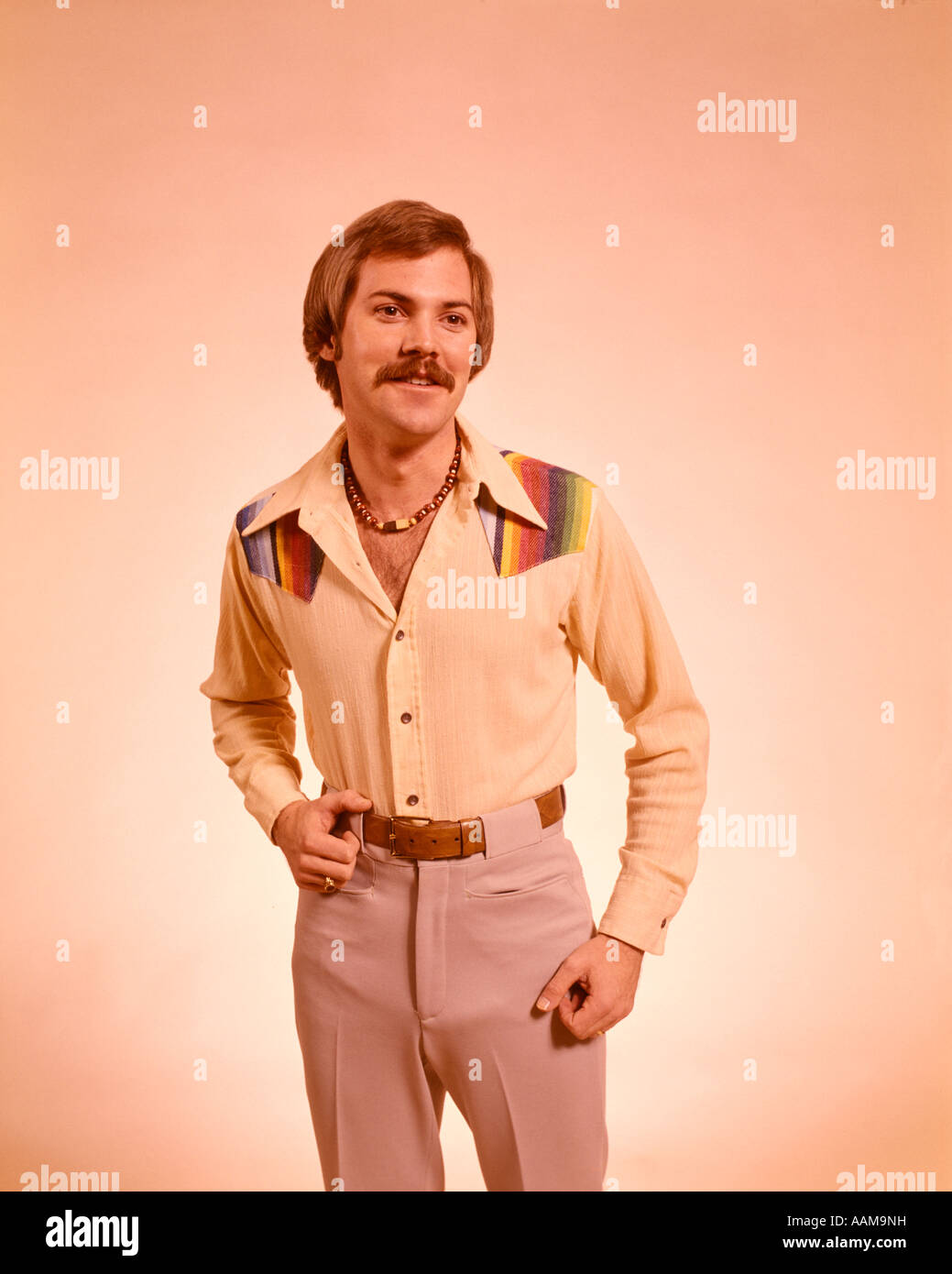 1970 1970s YOUNG MAN 3 4 FULL PORTRAIT MOUSTACHE NECKLACE CASUAL CLOTHES SHIRT PANTS FASHION STYLE RETRO Stock Photo